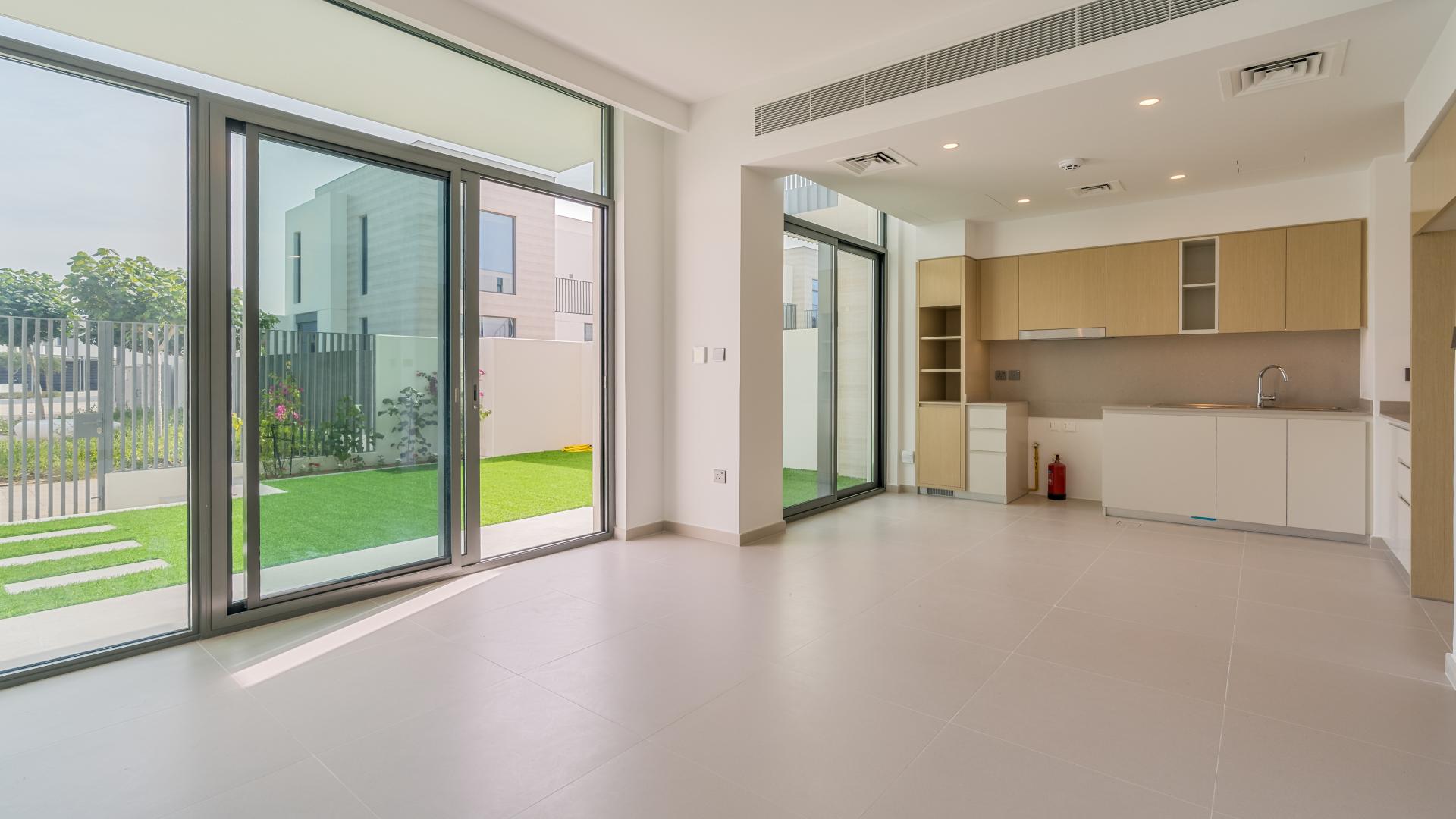 Backyard view of single-row villa in Sun, Arabian Ranches 3, with green lawn