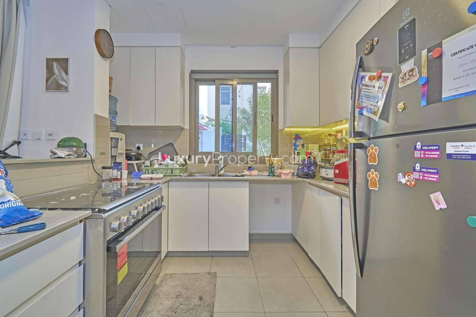 "Spacious living room in Zahra Townhouses, Town Square, featuring modern decor and ample seating.",Modern kitchen in Zahra Townhouses, Town Square, featuring sleek appliances and ample counter space