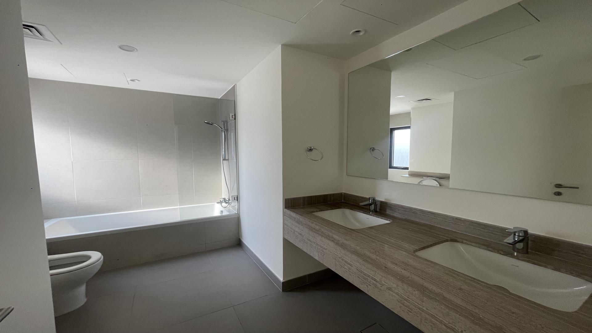 Modern bathroom in 3-bedroom villa, Dubai Hills Estate, featuring double sinks and glass shower