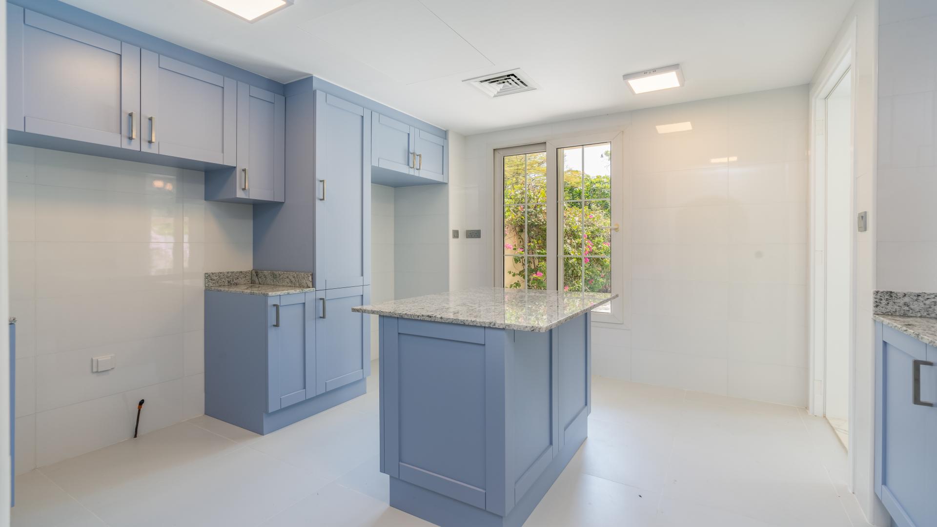 "Bright living room in 3-bedroom villa, The Springs 4, Emirates Living, for rent.",Modern kitchen with blue cabinets in 3-bedroom villa, The Springs 4, Emirates Living