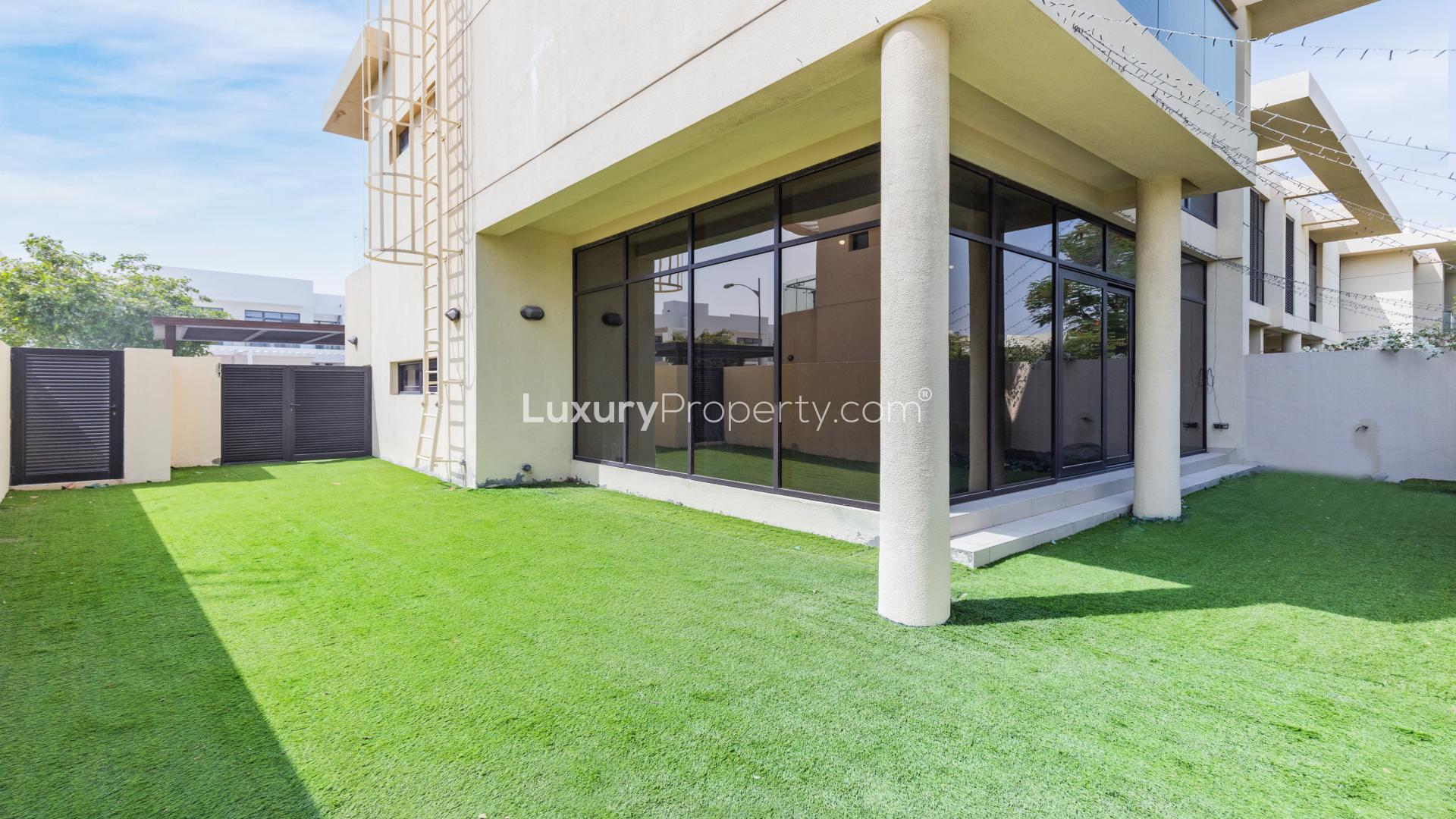 Luxurious villa exterior in Damac Hills' Phoenix community with lush greenery and modern design