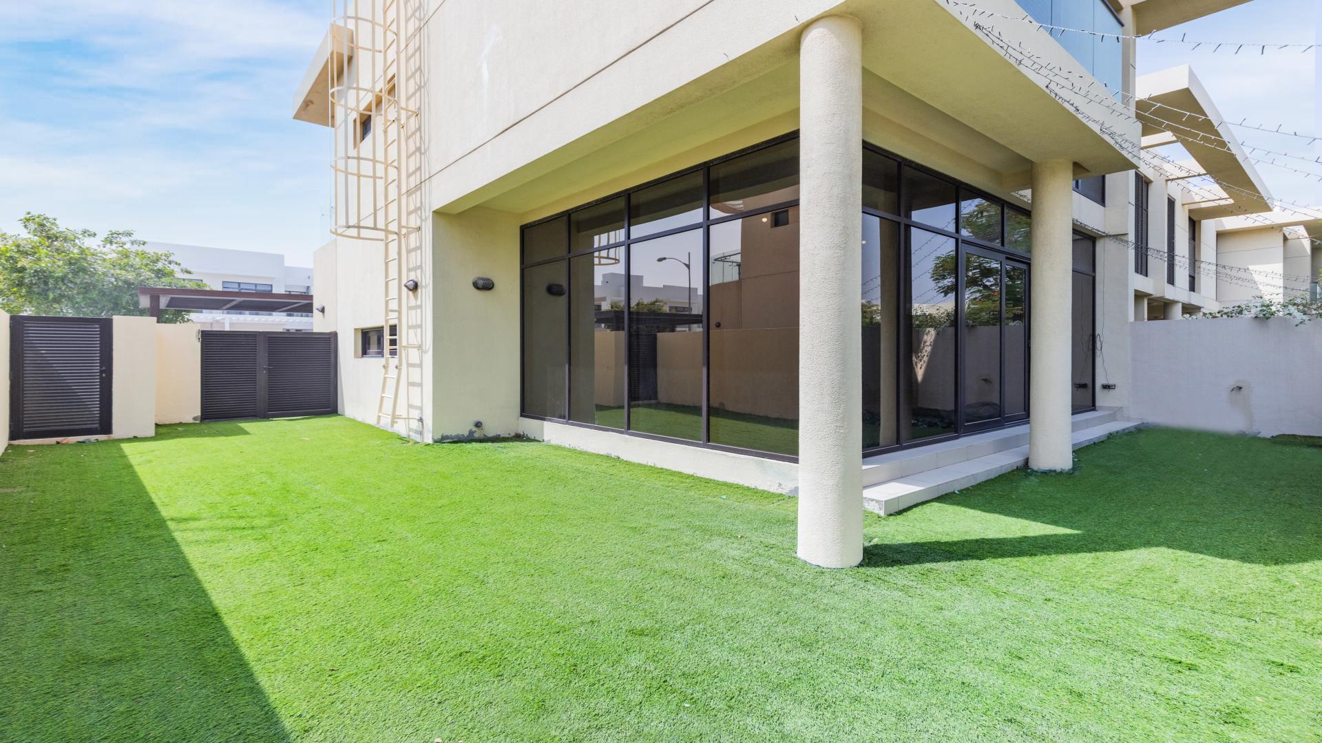 Luxurious villa exterior in Damac Hills' Phoenix community with lush greenery and modern design