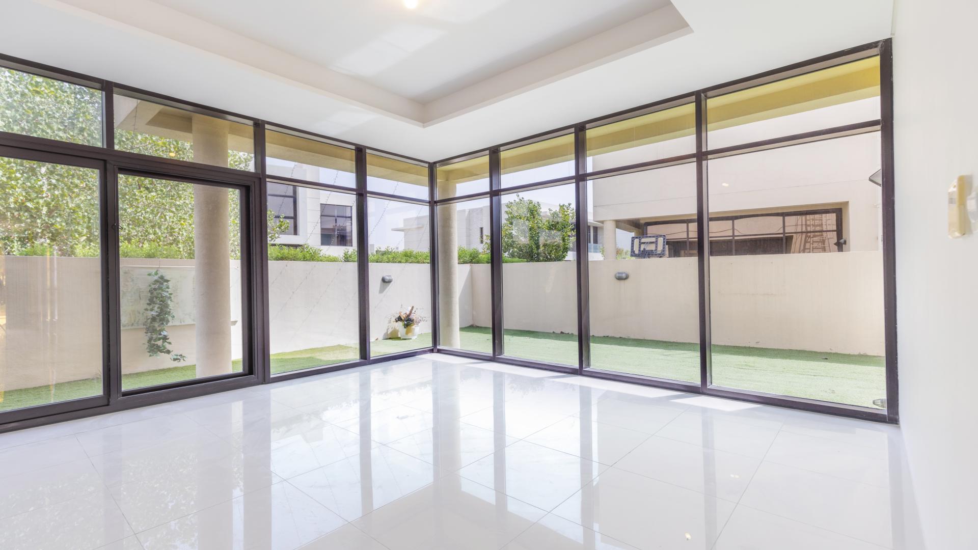 Luxurious villa exterior with green lawn in Damac Hills' Phoenix community