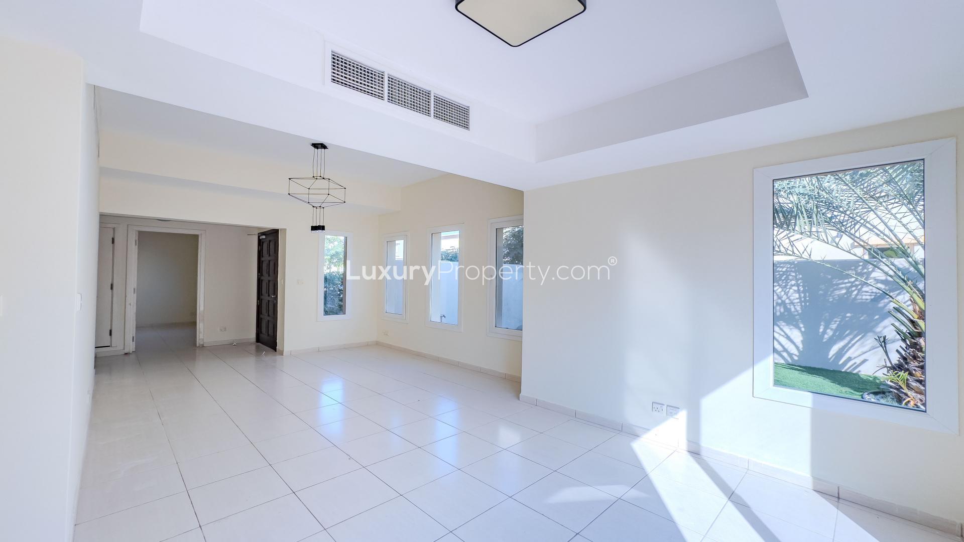 Bright living room in spacious 3-bedroom villa, The Springs, featuring large windows and garden view