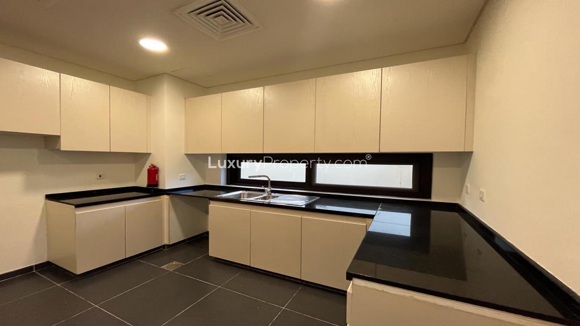 Modern kitchen in 3-bedroom villa, Damac Hills, Richmond community, featuring sleek cabinetry and countertops