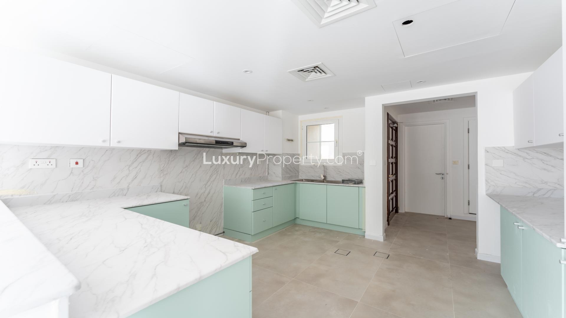 Modern kitchen with white cabinets and marble countertops in Springs 14 villa for rent