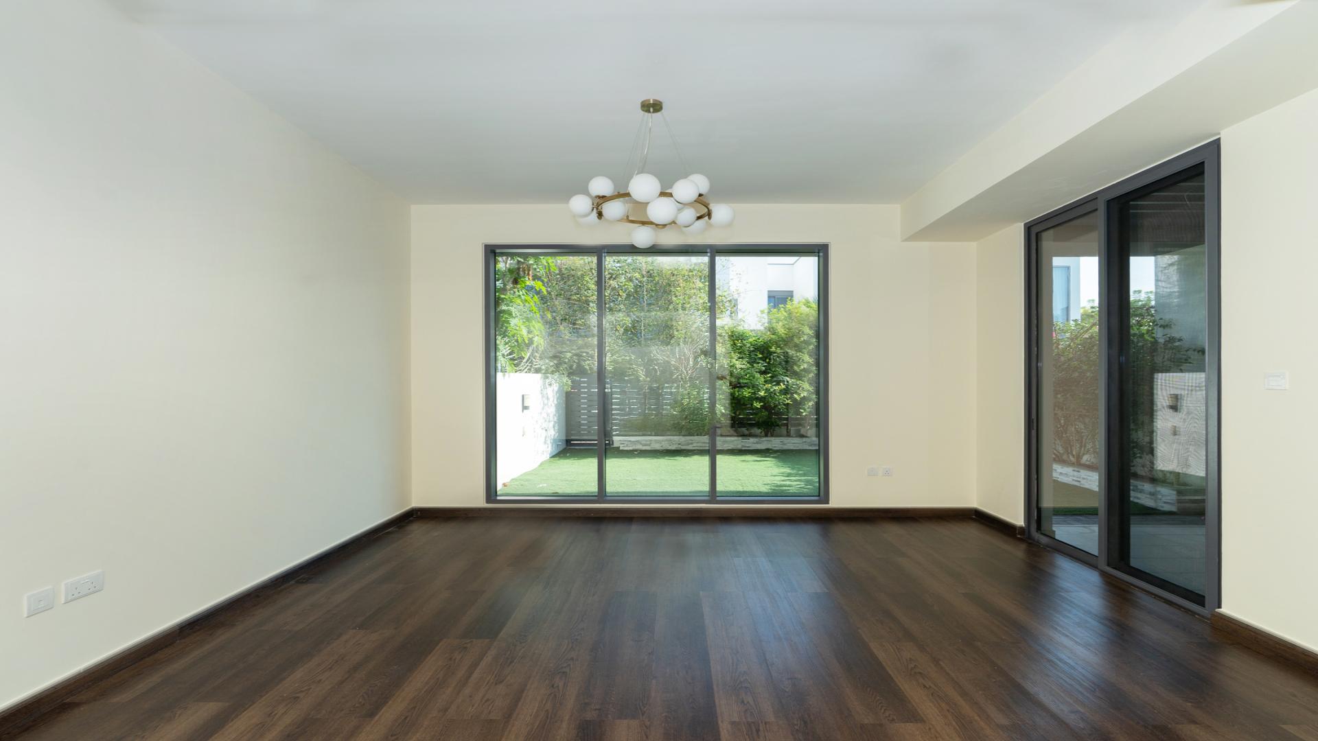 "Modern 3-bedroom villa exterior in Dubai Hills Estate, Maple 3 community, available for rent.",Spacious living room with garden view in Dubai Hills Estate villa for rent