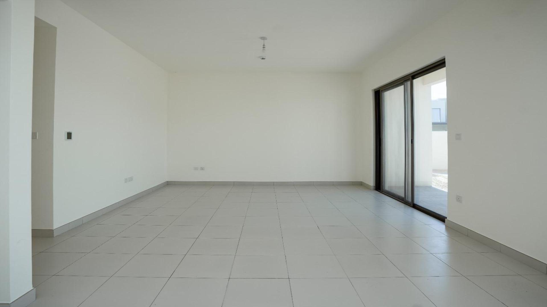 Empty living room in Emaar South Parkside villa for rent, featuring sliding glass doors