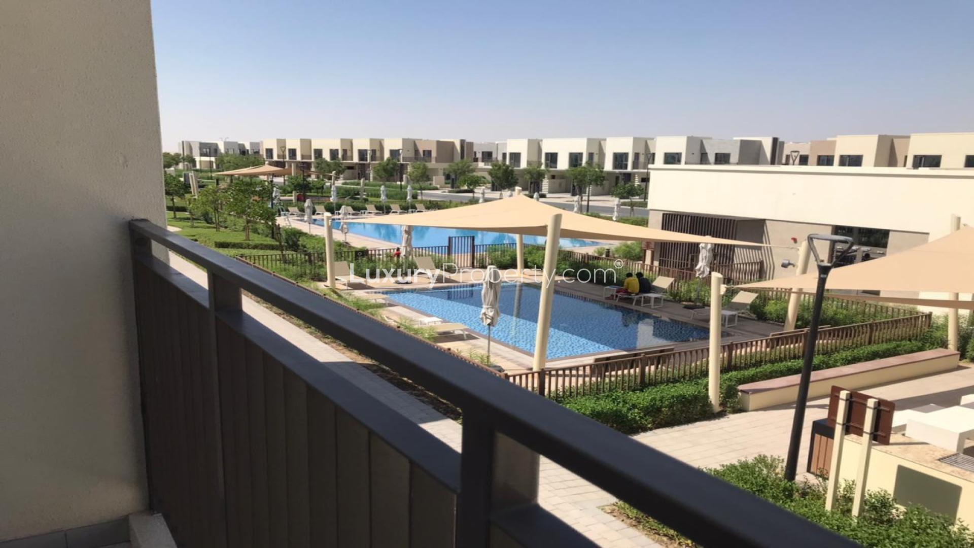 "Spacious kitchen and living area in Emaar South Parkside villa for rent, LP47490.",View of pool and garden from Parkside villa balcony in Emaar South community