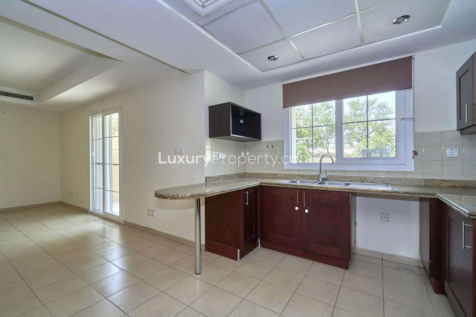 Modern kitchen in Al Reem 3 villa, Arabian Ranches, featuring granite countertops and wooden cabinets