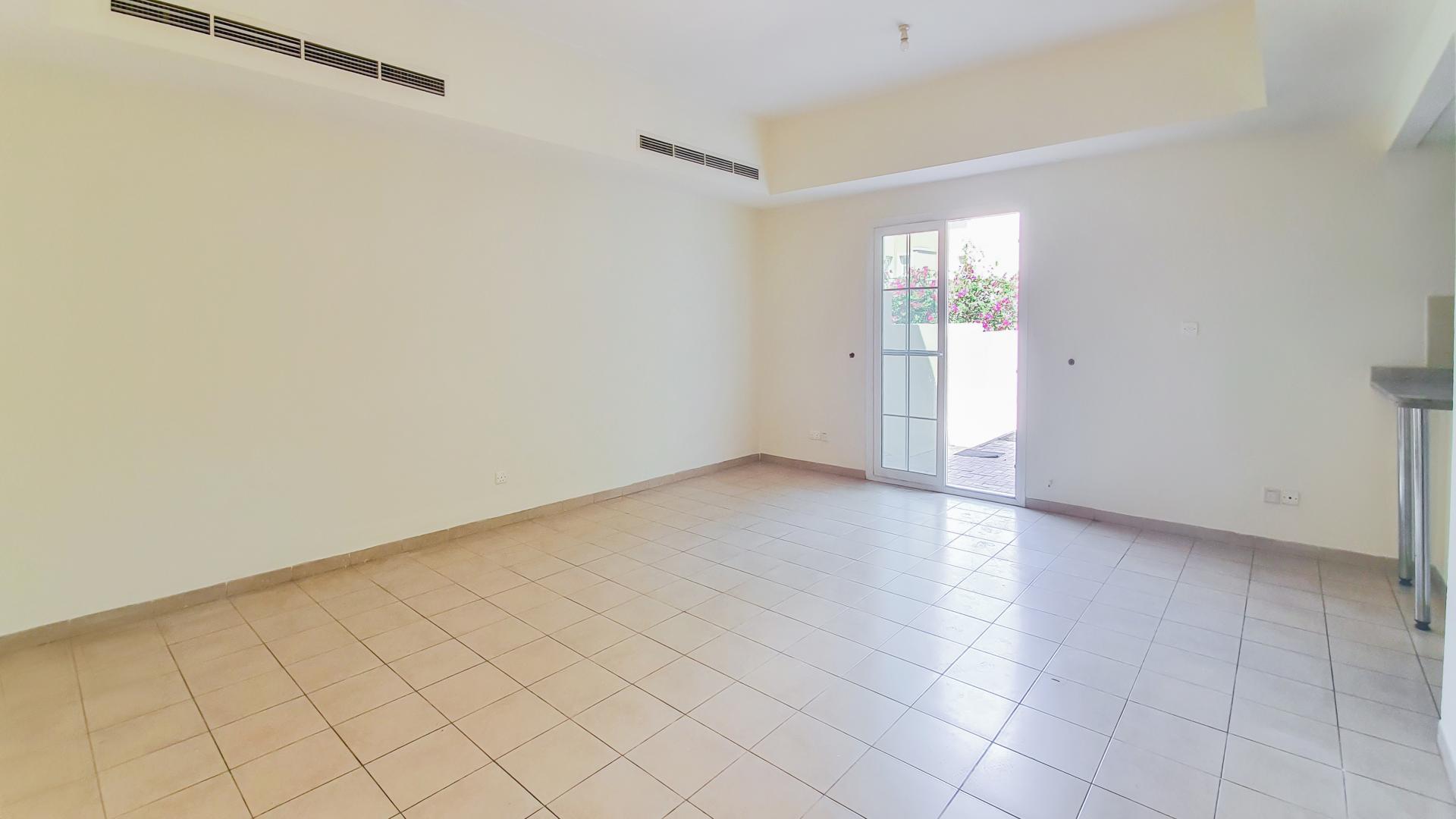 N/A,Empty living room in 3-bedroom townhouse, Al Reem, Arabian Ranches, with tiled floor and patio door
