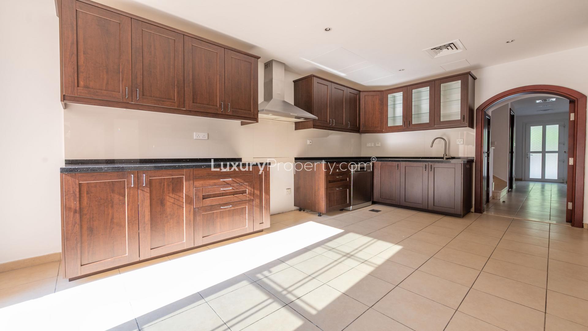 Modern kitchen in Type 2E corner villa, Arabian Ranches, featuring dark wood cabinets