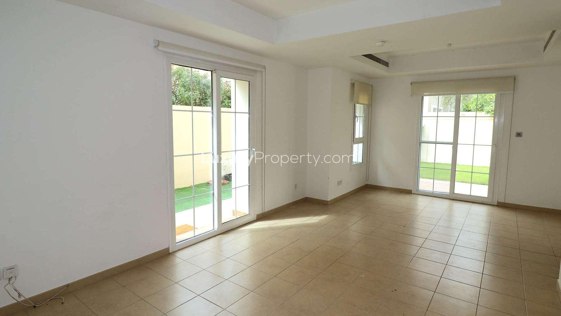 Spacious end-unit villa exterior in Al Reem, Arabian Ranches, with lush garden view