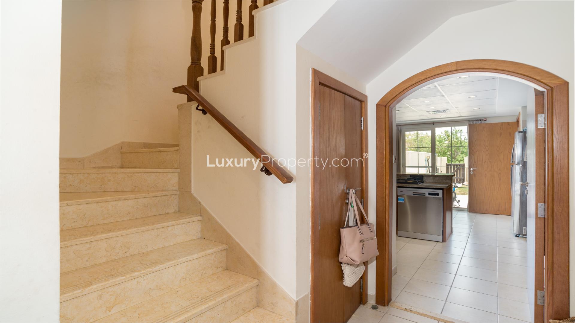 Modern kitchen in Al Reem villa, Arabian Ranches, with garden view through glass doors