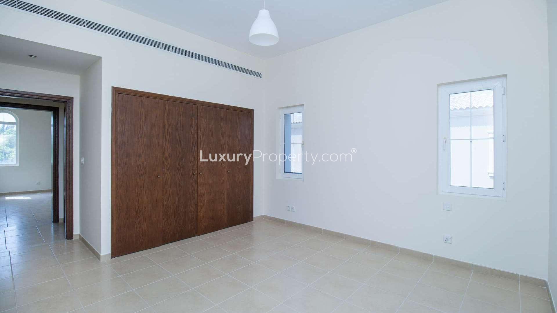 Empty living room in three-bedroom villa, Alvorada, Arabian Ranches, with large windows and balcony