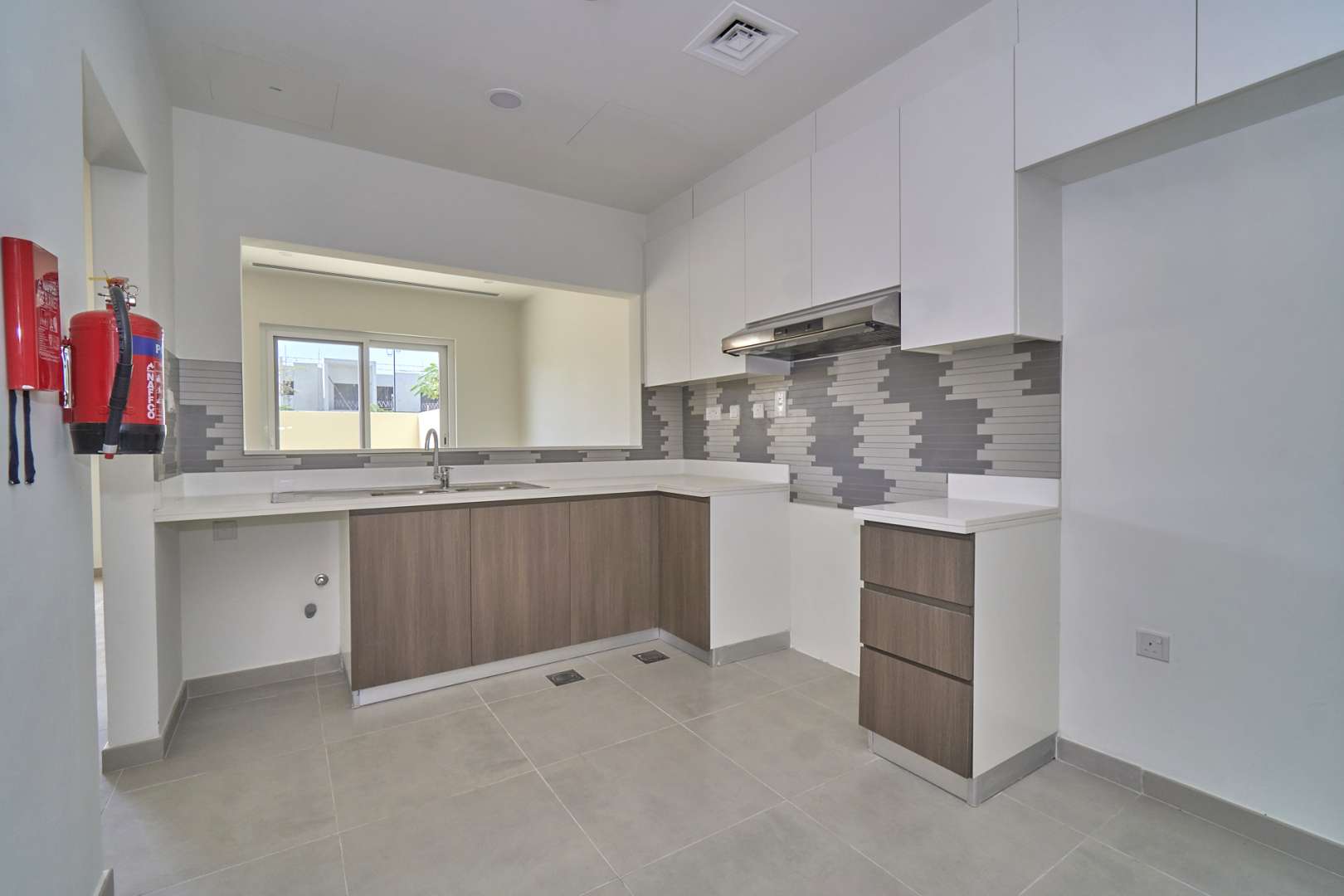 Bright, spacious living area in Villanova villa, Dubai Land, featuring large windows and modern design