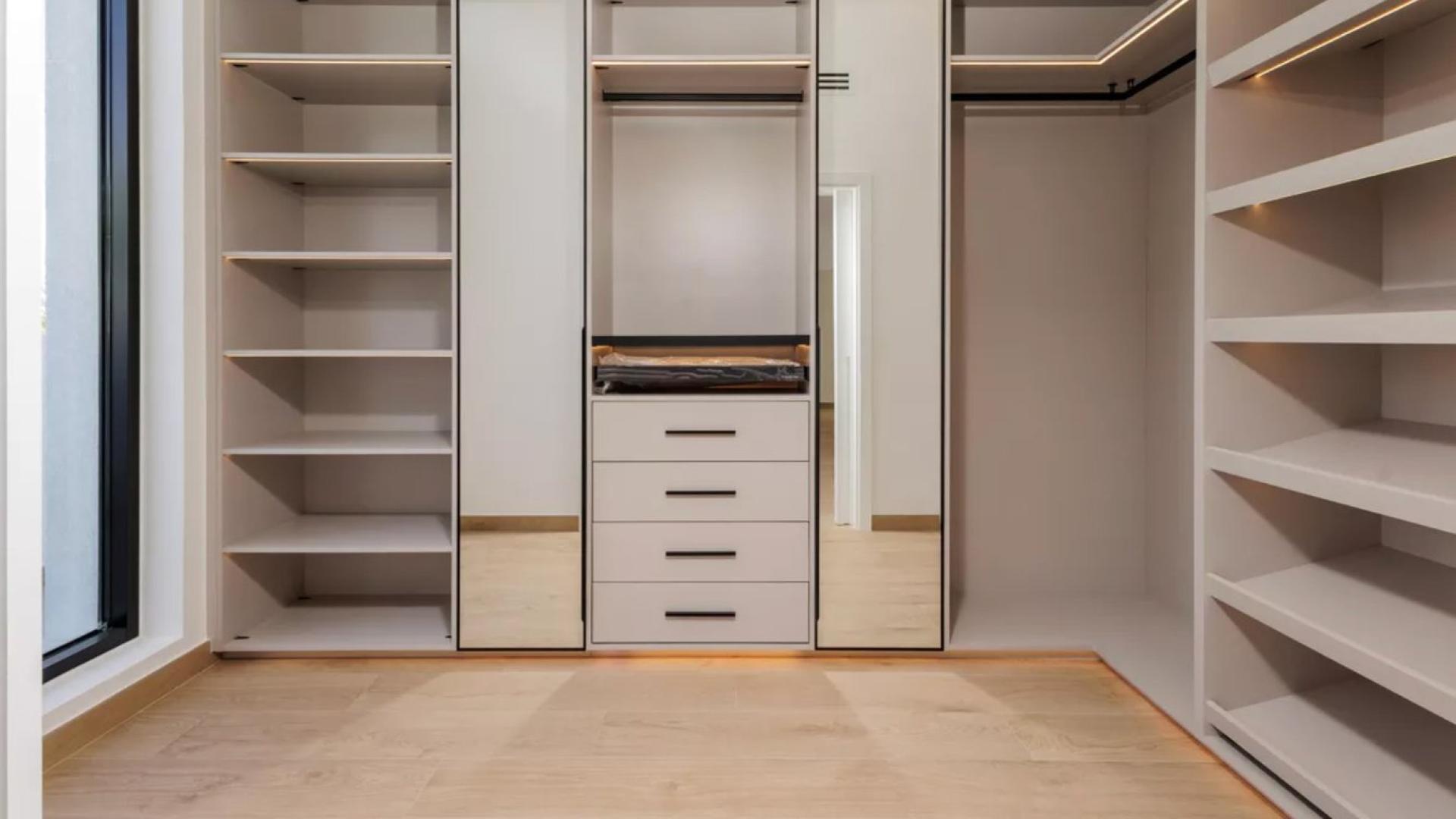 Spacious master bedroom in lakefront villa, Jumeirah Islands, with modern decor and natural light