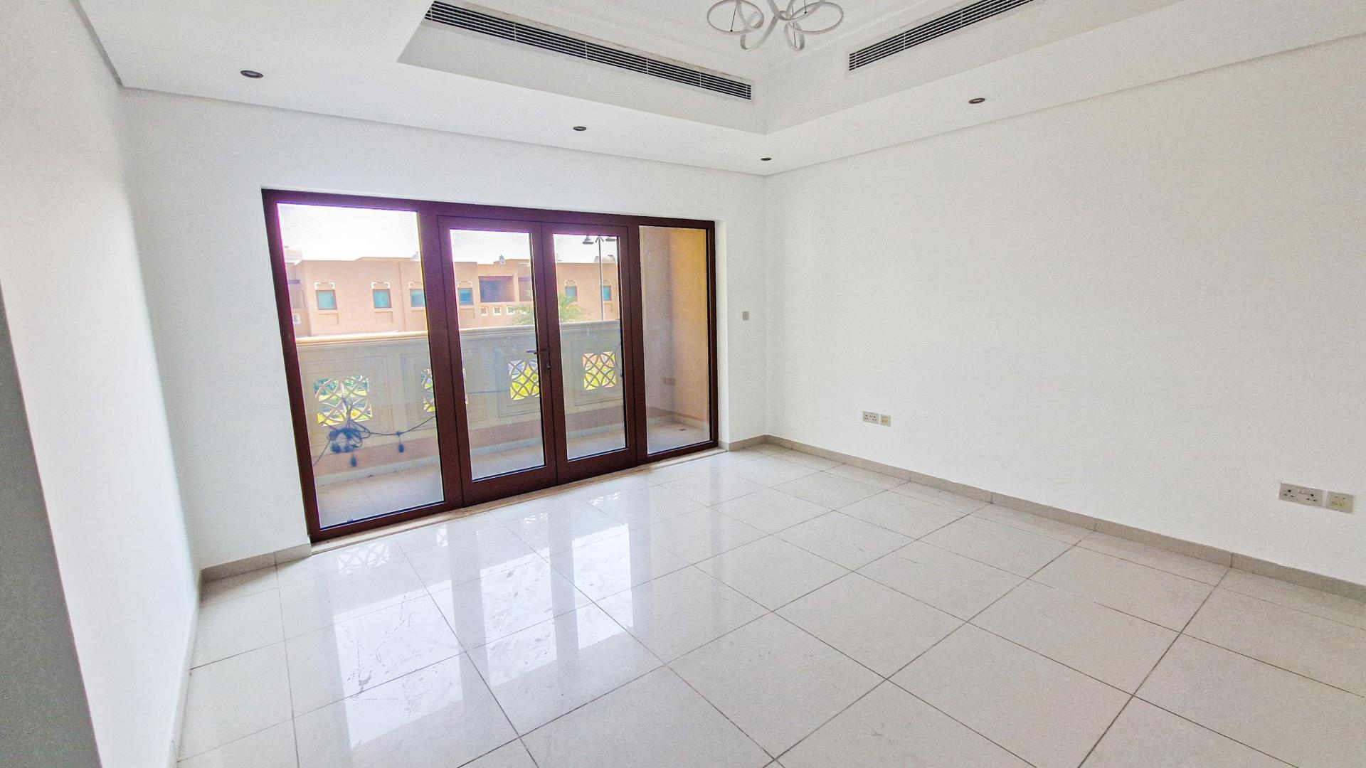 "Spacious kitchen and dining area in Al Furjan East villa, Dubai style, LP45908.","Spacious living room with large windows in Al Furjan East villa for rent.",Kitchen interior of Dubai style villa, Al Furjan East, featuring modern countertops and wooden cabinets