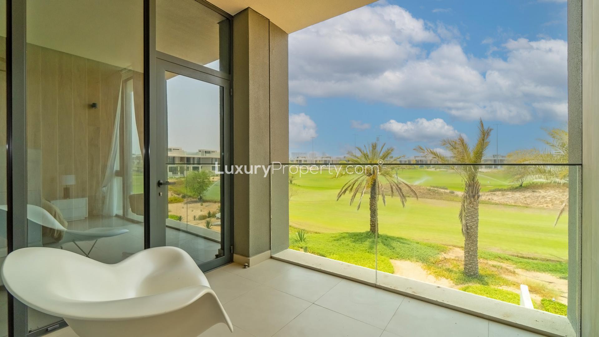 "Dubai Hills Estate villa garden view with loungers, palm trees, and lush greenery.",Balcony view of golf course at Club Villas, Dubai Hills Estate. Single row villa rental