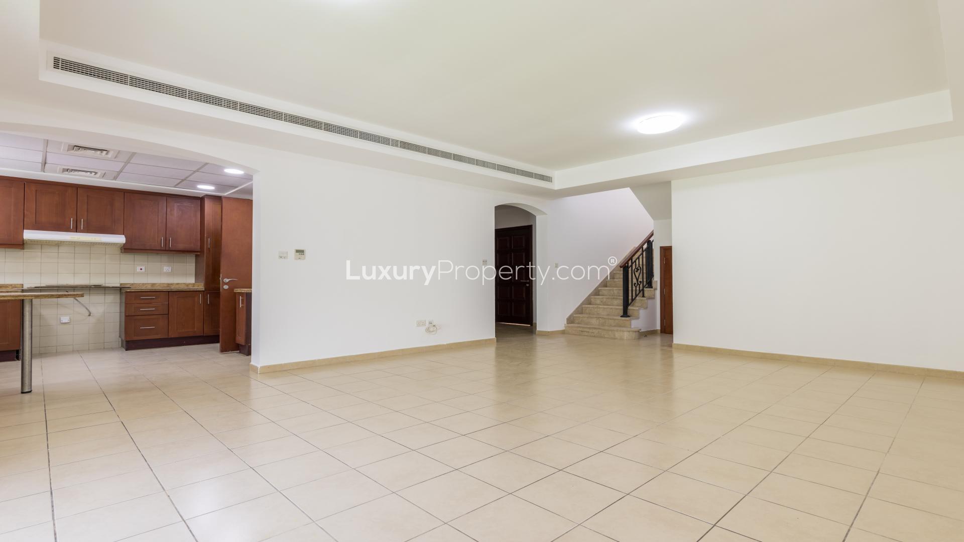 "Spacious backyard of 3M villa for rent in Ghadeer, The Lakes community.","Spacious living area with open kitchen in Ghadeer, The Lakes, Type 3M villa for rent.",Spacious living room with tiled floor in Ghadeer villa, The Lakes, for rent
