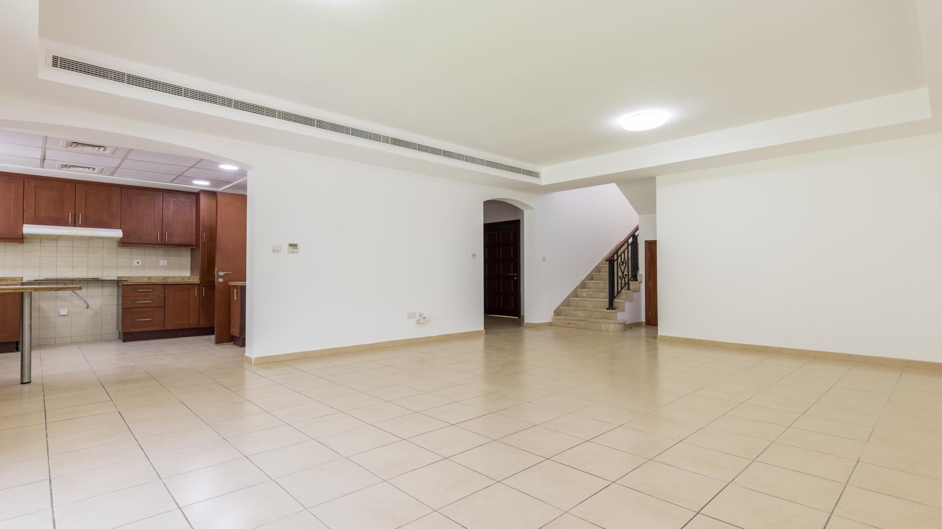 "Spacious backyard of 3M villa for rent in Ghadeer, The Lakes community.","Spacious living area with open kitchen in Ghadeer, The Lakes, Type 3M villa for rent.",Spacious living room with tiled floor in Ghadeer villa, The Lakes, for rent
