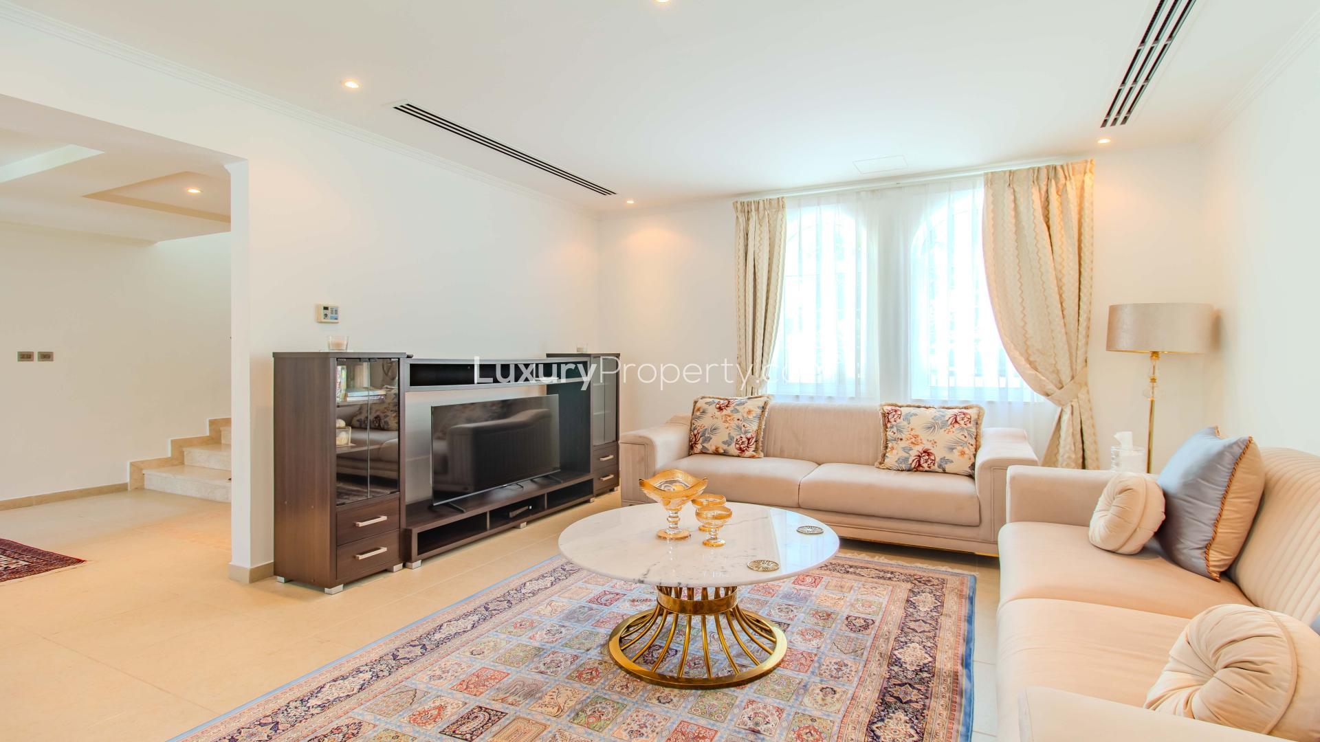 Luxurious living room in Jumeirah Park Legacy Villa with elegant decor and dining area