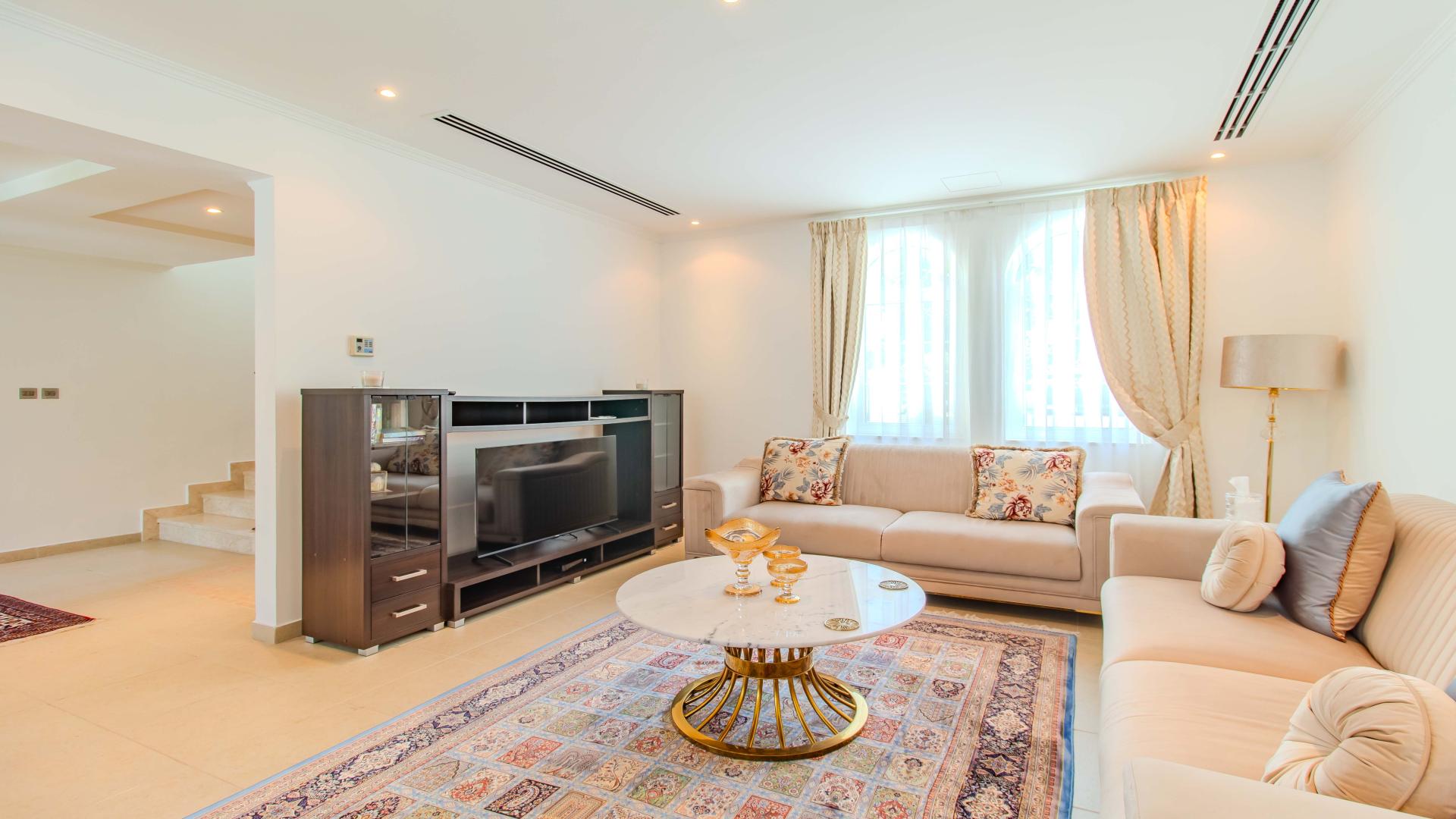 Luxurious living room in Jumeirah Park Legacy Villa with elegant decor and dining area