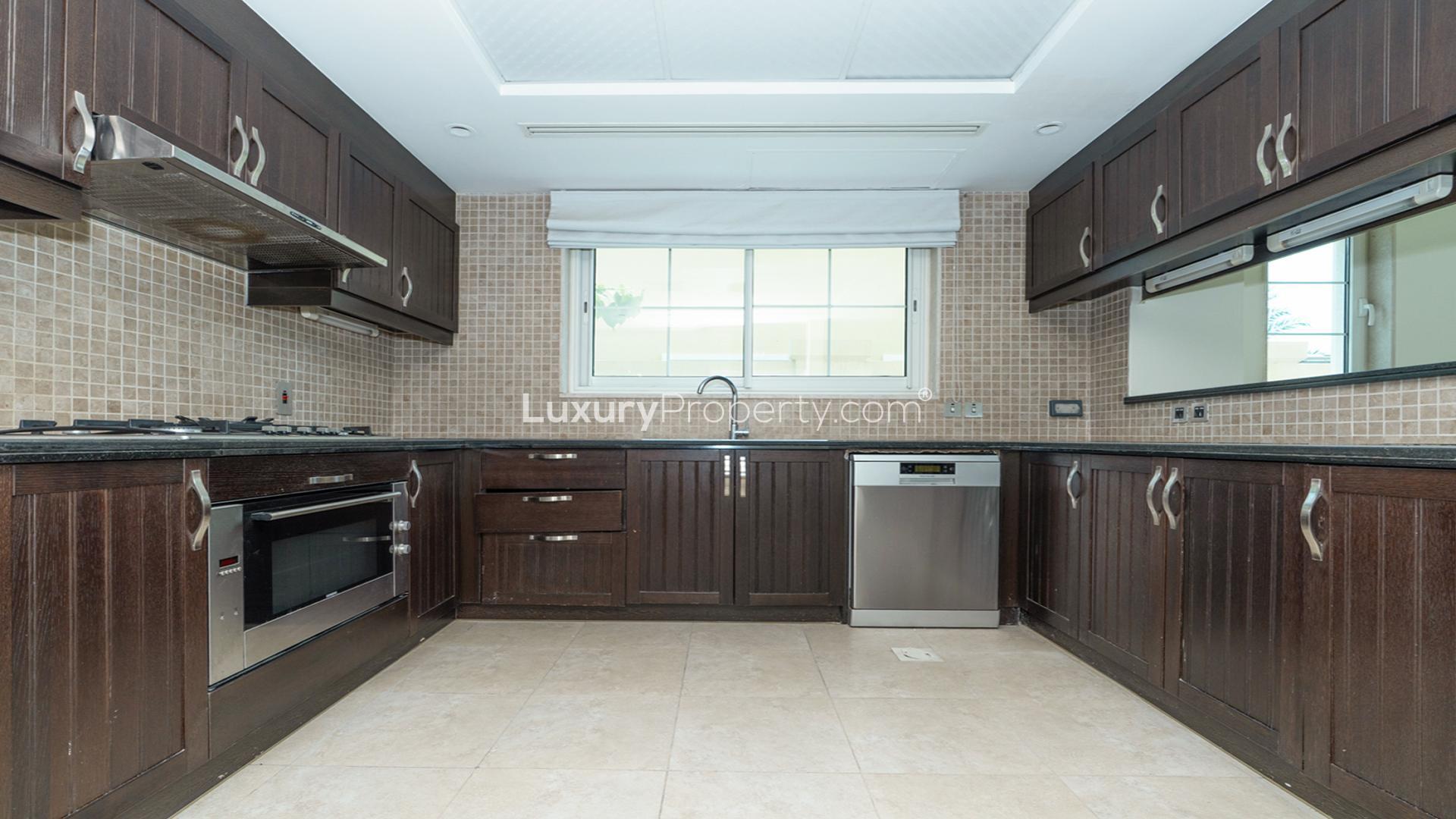 Modern kitchen with dark wood cabinets in Jumeirah Park villa, Legacy sub-community