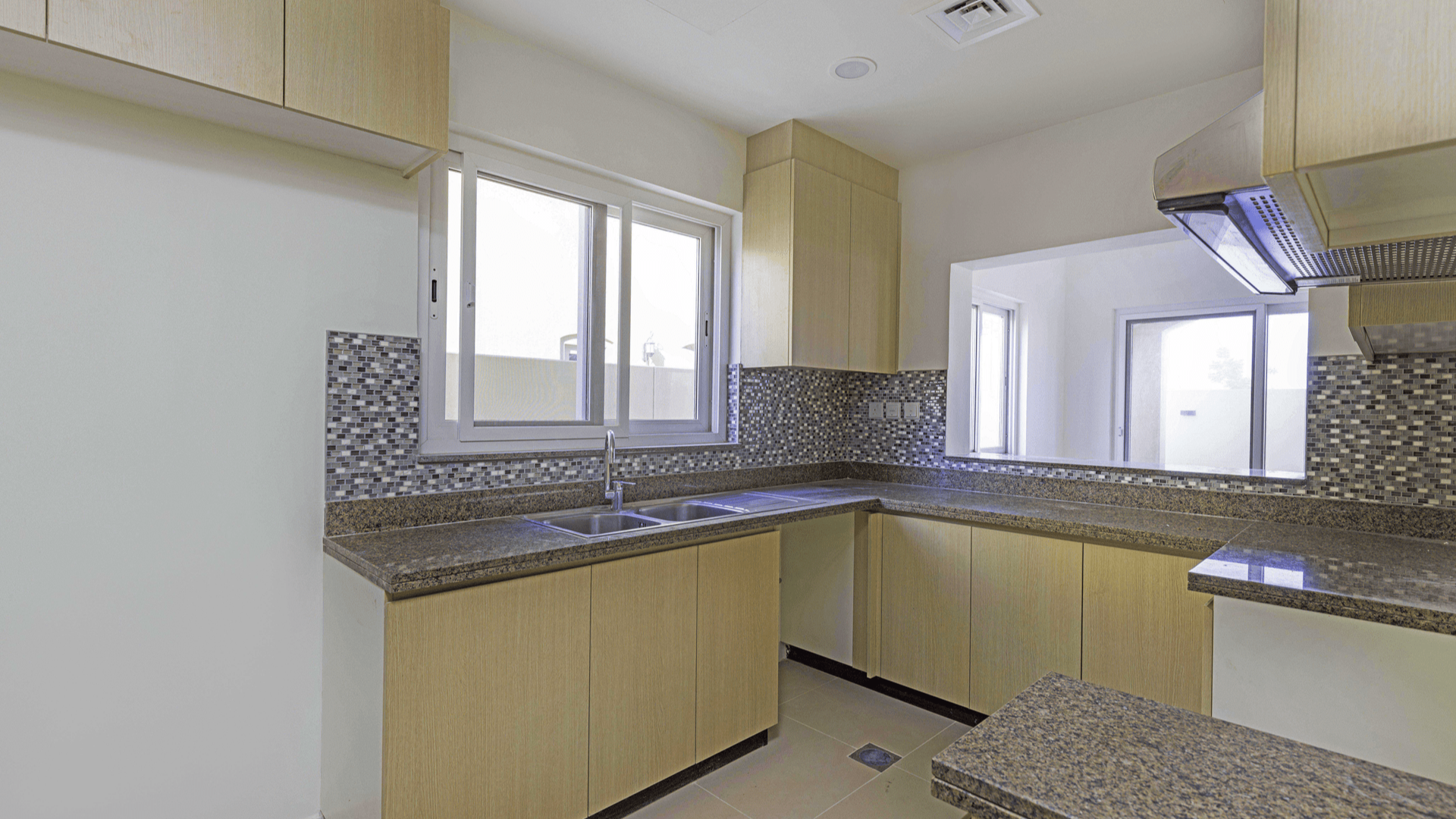 Empty room with tiled floor and large window in Villanova, Dubai Land villa for rent