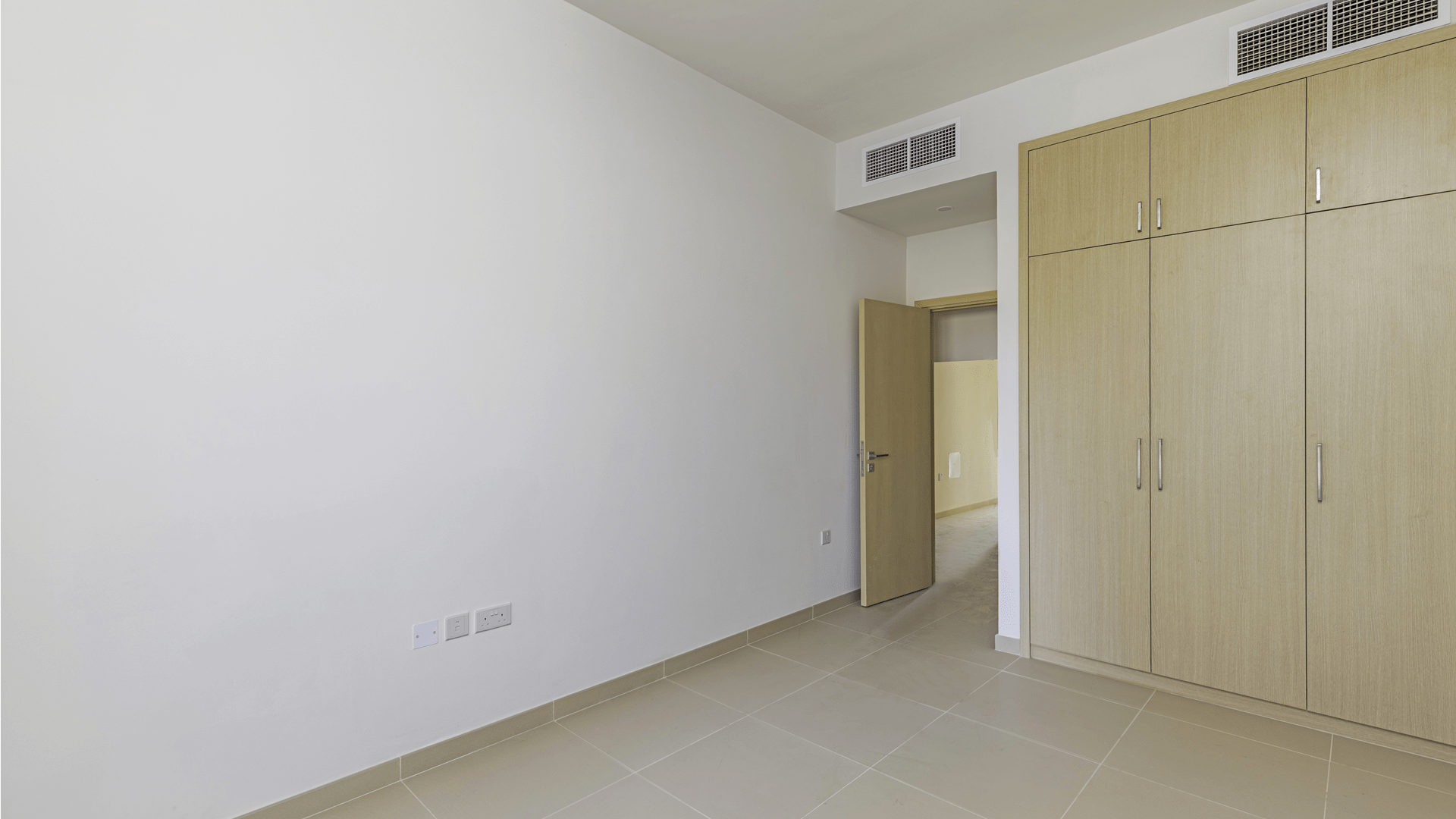 Balcony view of Villanova villa in Dubai Land, showcasing community landscape and clear skies