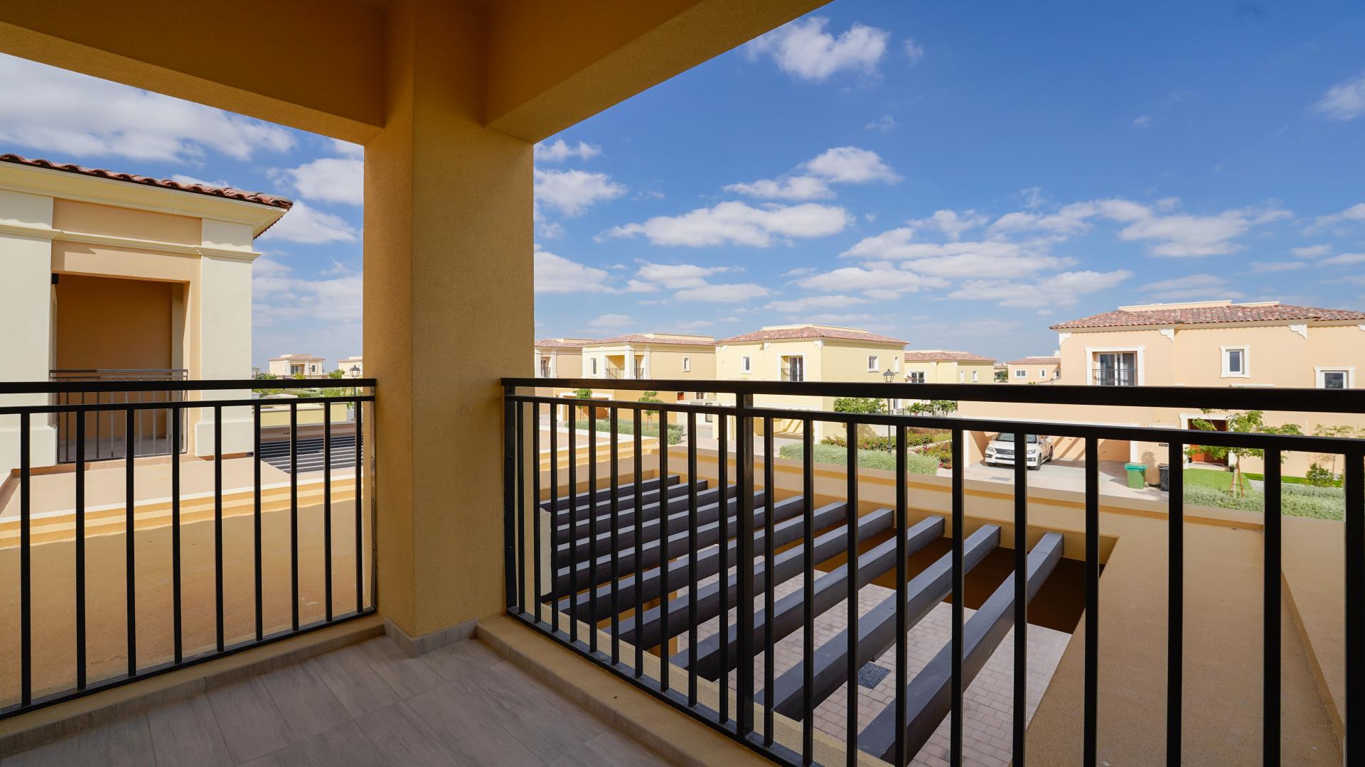 Balcony view of spacious villa in Villanova, Dubai Land, featuring sunny neighborhood scenery