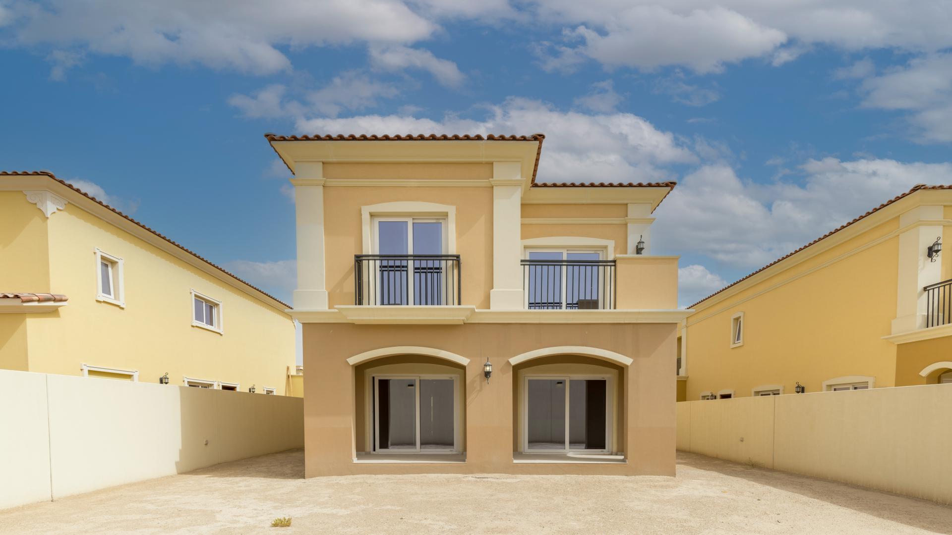 Balcony view of Villanova villa in Dubai Land, showcasing nearby residential units