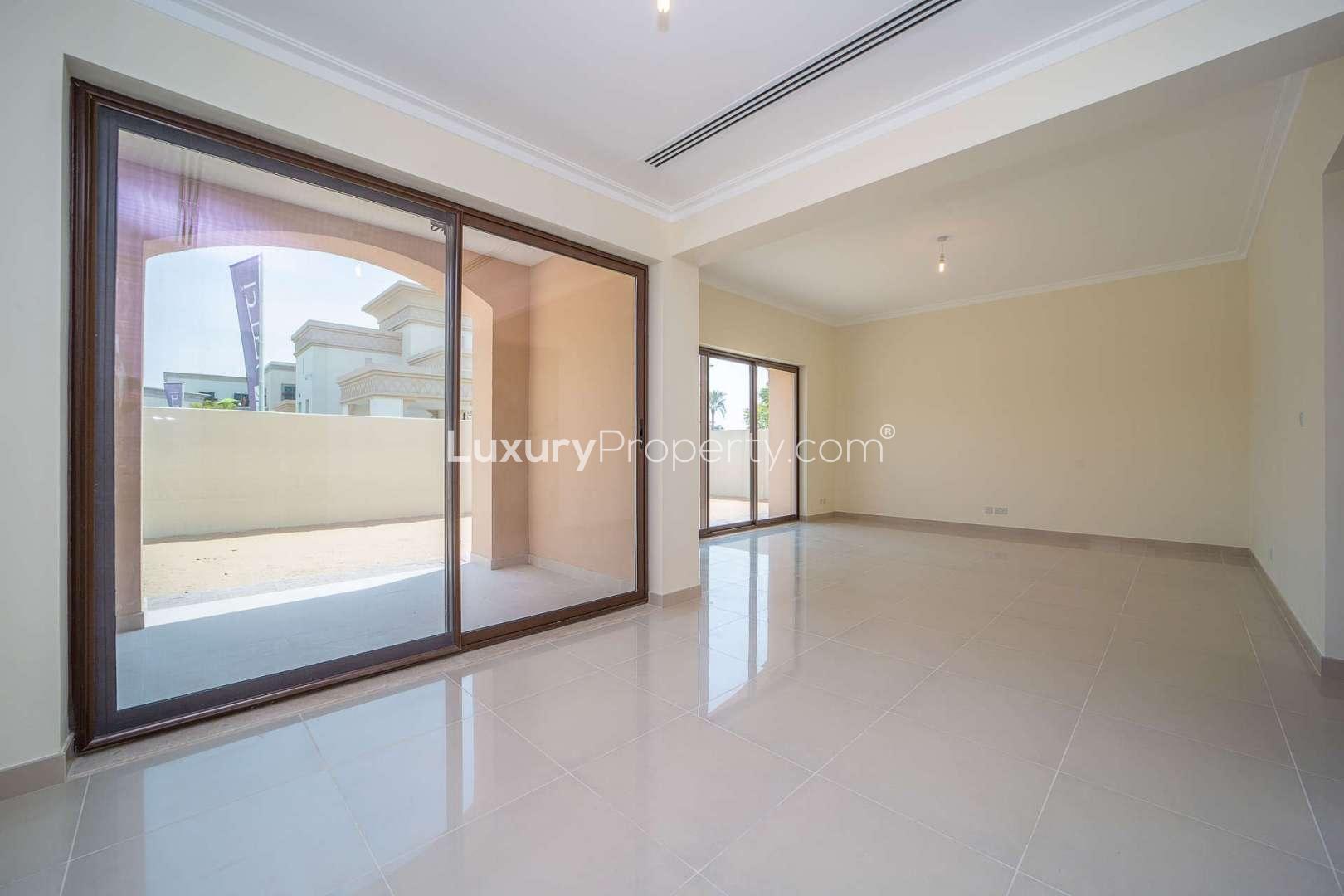 "Bright living room in Spanish-style villa, Lila, Arabian Ranches 2, Dubai, with balcony view.",Spacious living area with large windows in Lila, Dubai, 3-bedroom villa for rent