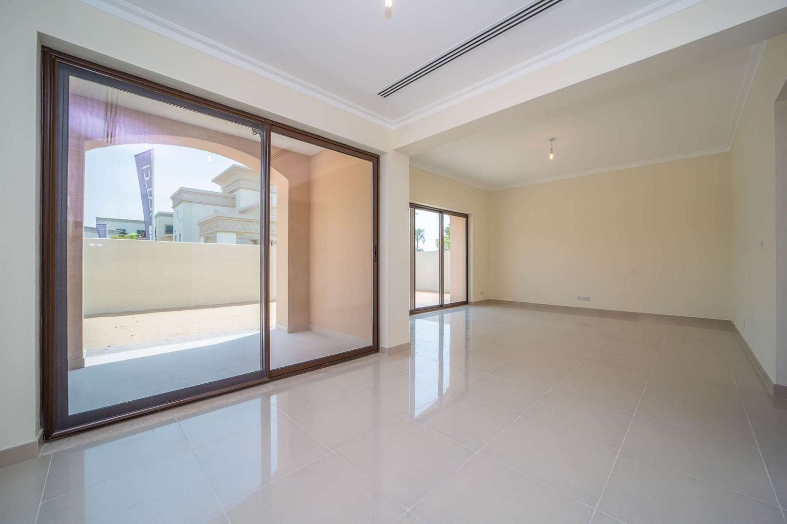 "Bright living room in Spanish-style villa, Lila, Arabian Ranches 2, Dubai, with balcony view.",Spacious living area with large windows in Lila, Dubai, 3-bedroom villa for rent