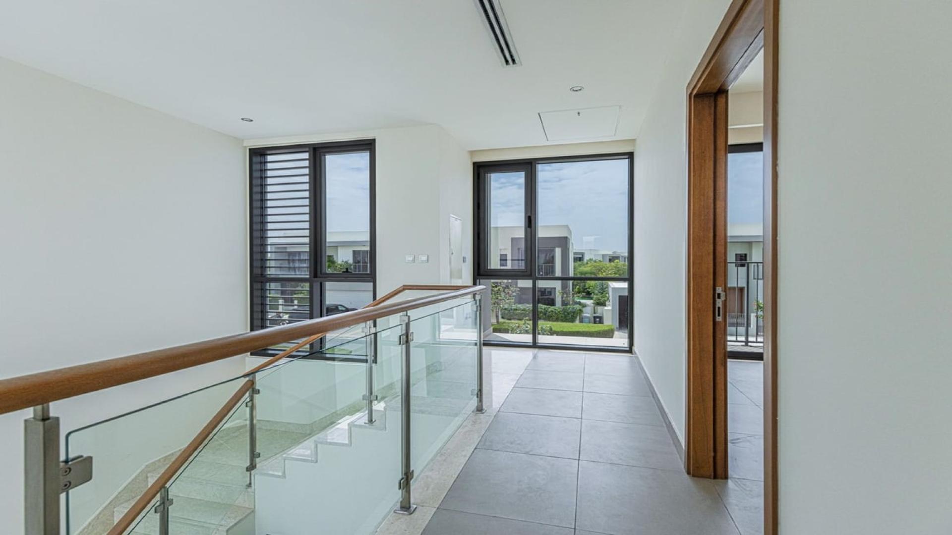 "Spacious kitchen and living area in 3-bedroom Sidra villa at Dubai Hills Estate.",Modern hallway with glass railing in Sidra Villas, Dubai Hills Estate