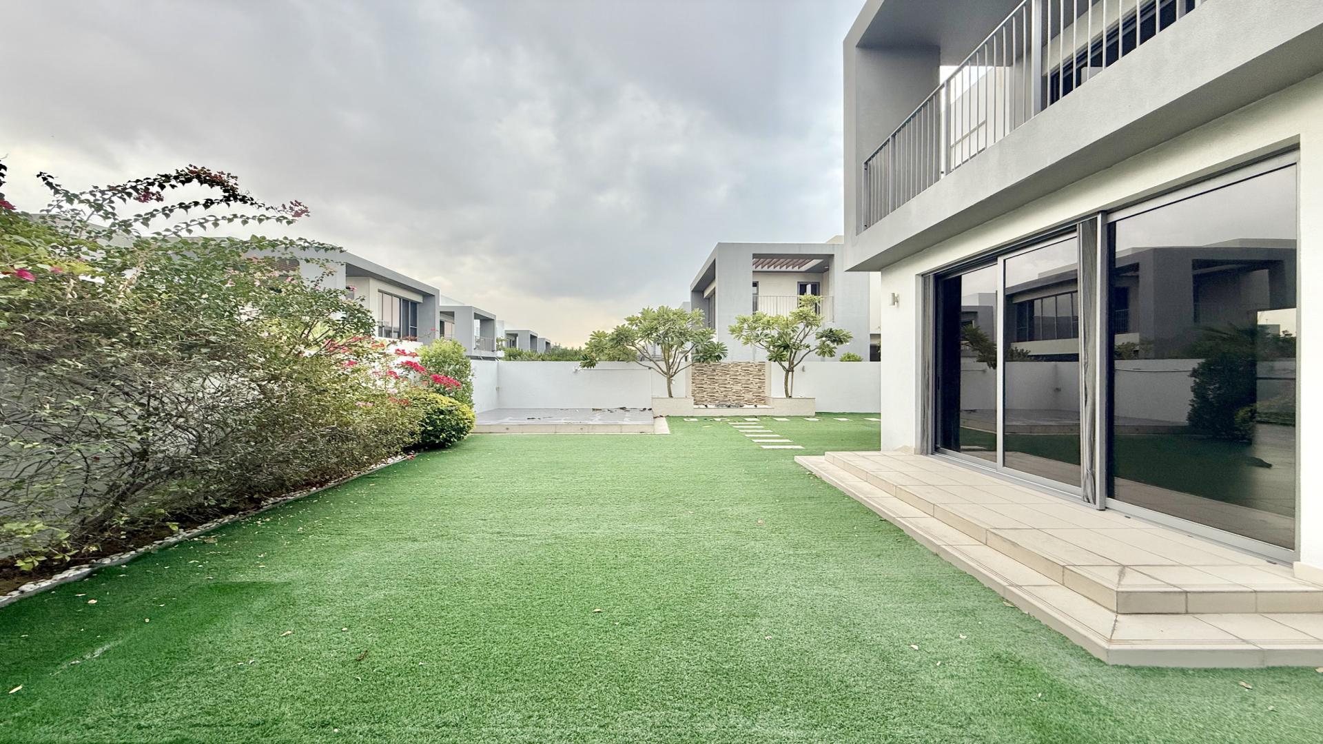 Exterior view of villa garden in Sidra, Dubai Hills Estate, with lush greenery and pathway