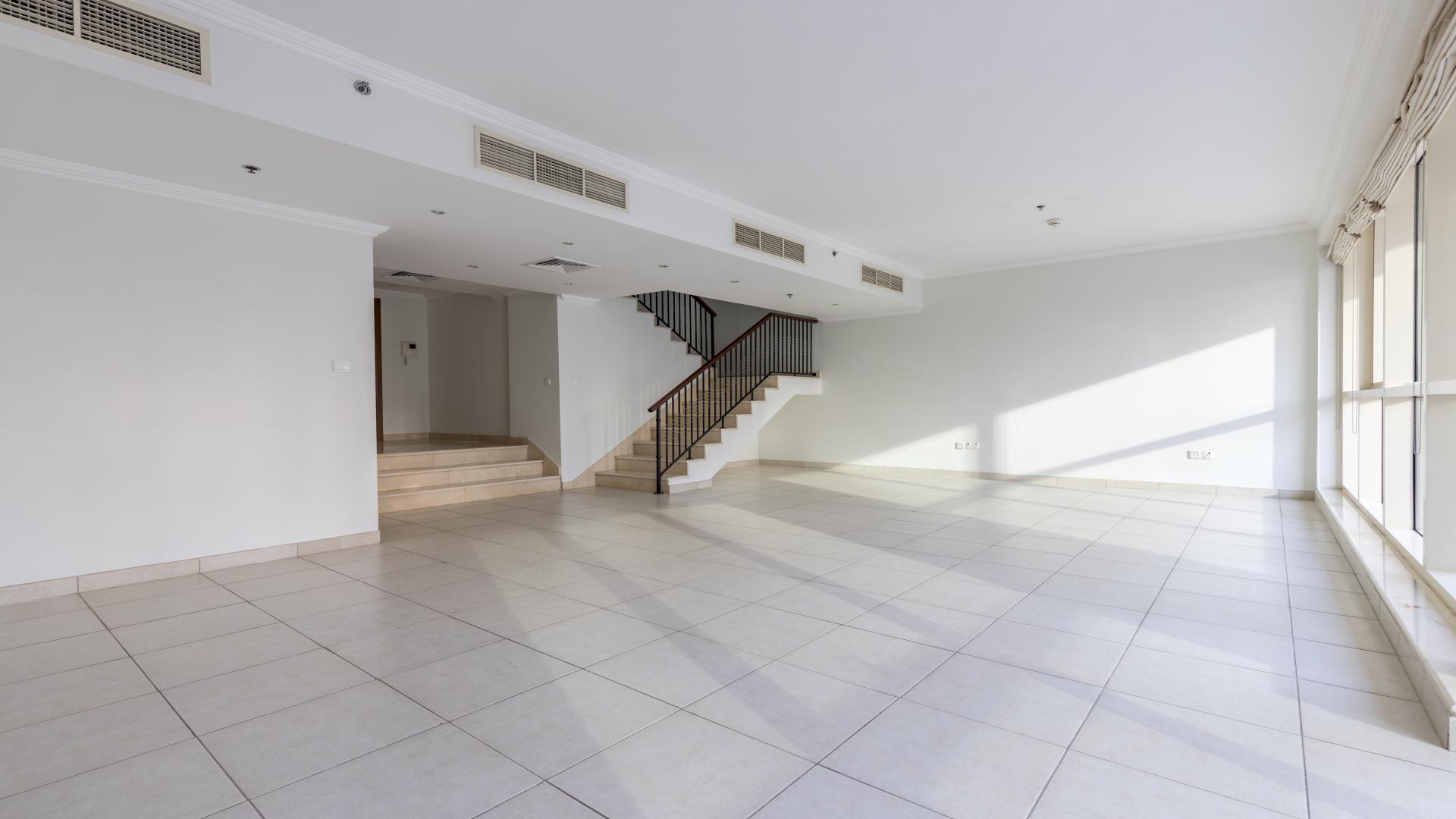 "View from Marina Quays duplex balcony overlooking Dubai Marina waterfront and modern skyscrapers.",Spacious living area with staircase in 3-bedroom duplex, Marina Quays, Dubai Marina