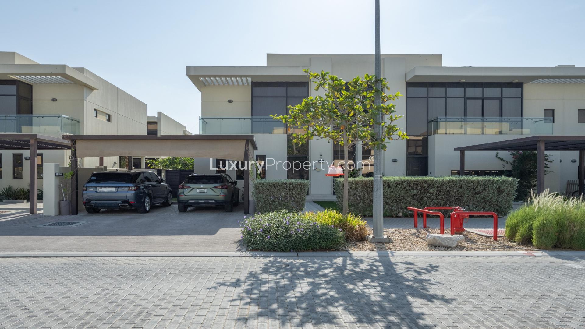 Modern villa exterior with lush garden in Akoya Park, DAMAC Hills, for rent