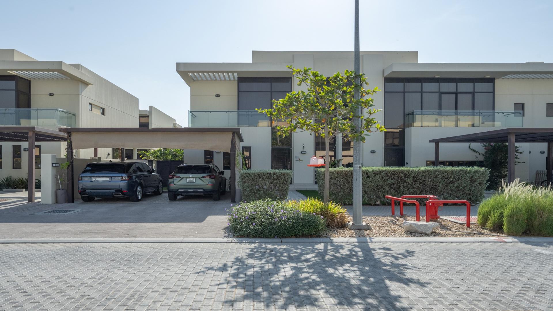 Modern villa exterior with lush garden in Akoya Park, DAMAC Hills, for rent