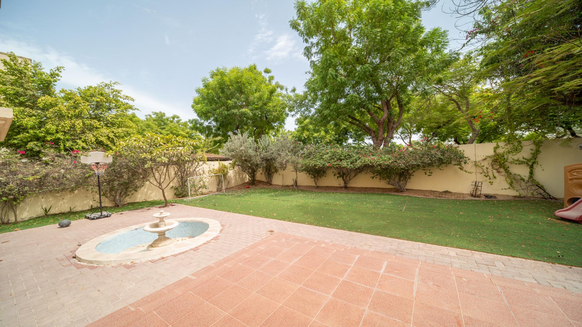 "Meadows 9 villa exterior with garden and patio, partial lake view, 3 bedrooms.",Backyard of Meadows 9 villa with patio and garden in Dubai residential community