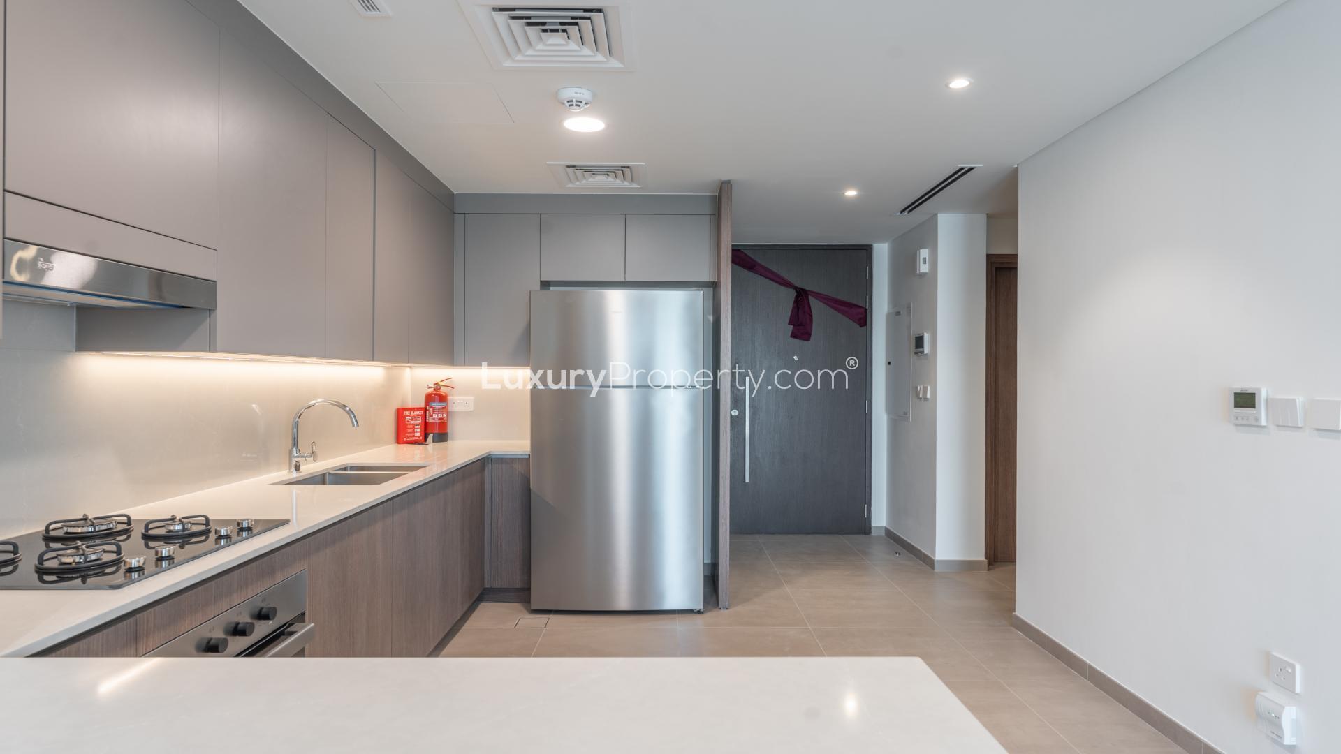 Modern kitchen in Elan villa, Tilal Al Ghaf; stainless appliances, sleek design, ample space