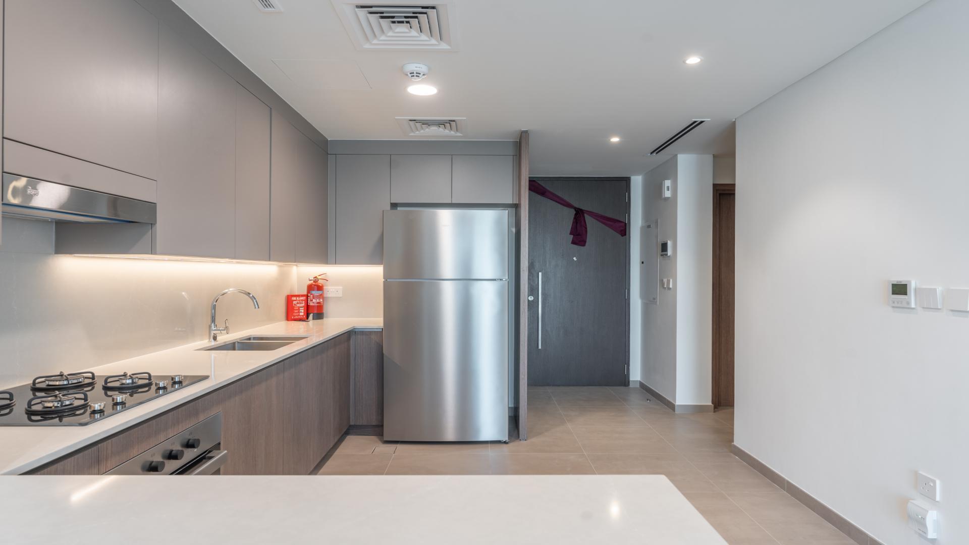 Modern kitchen in Elan villa, Tilal Al Ghaf; stainless appliances, sleek design, ample space