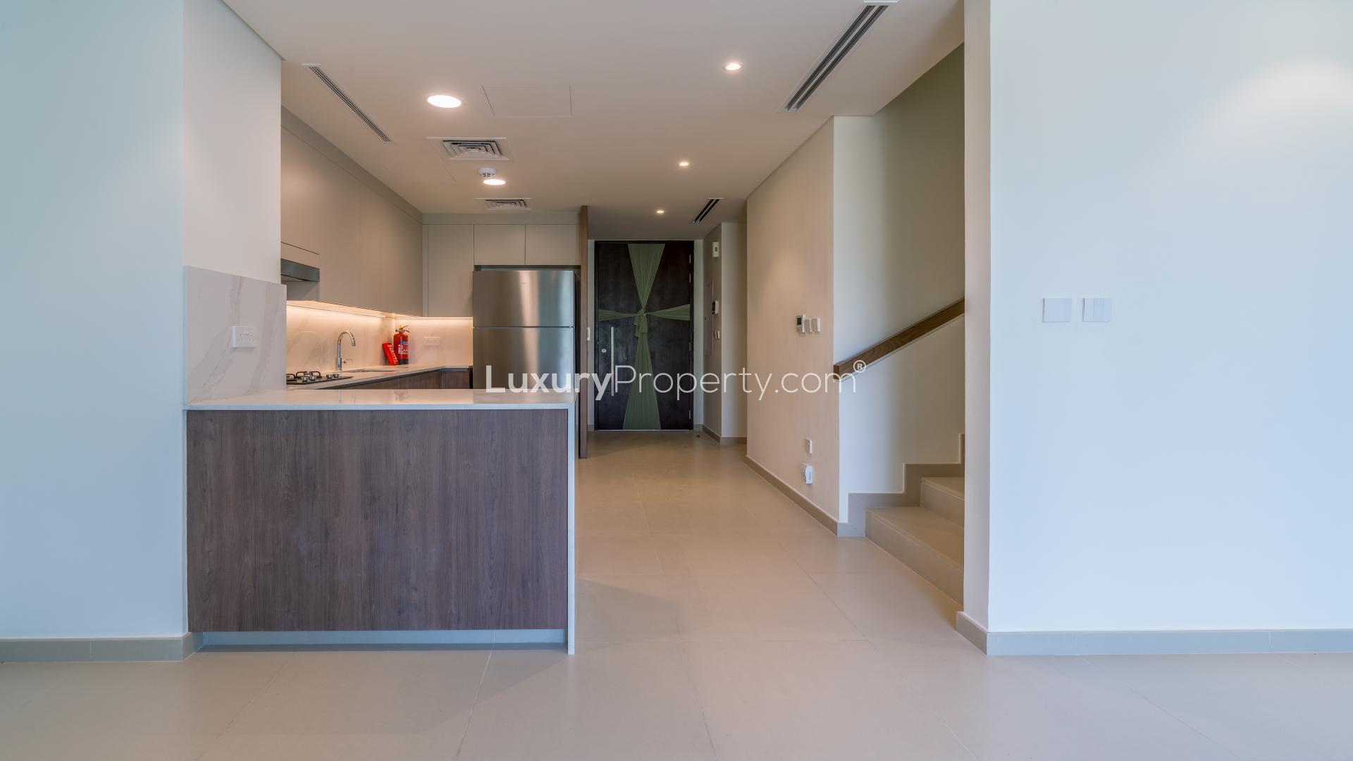 Modern kitchen in 3-bedroom Elan Villa, Tilal Al Ghaf, featuring sleek cabinetry and appliances