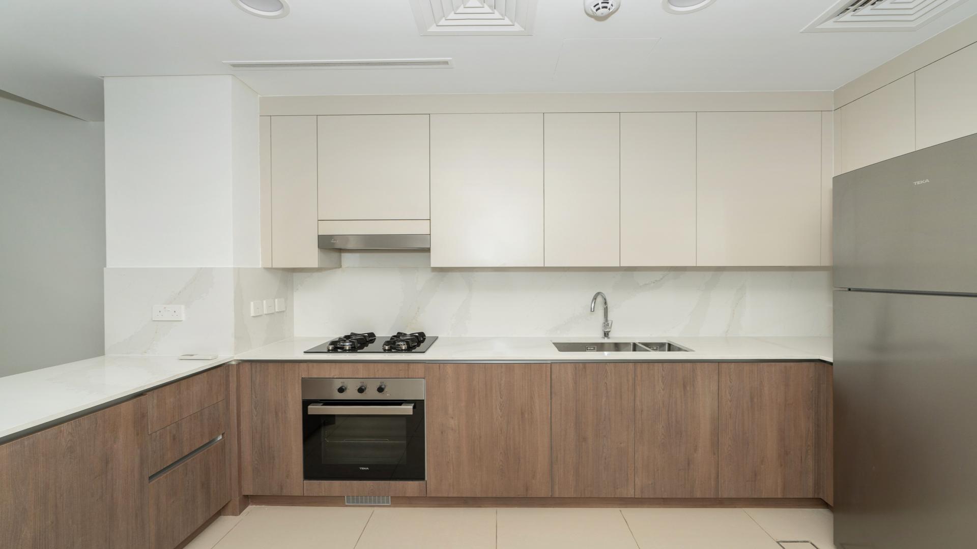 Modern kitchen in Elan villa, Tilal Al Ghaf; sleek cabinets, built-in oven, spacious layout