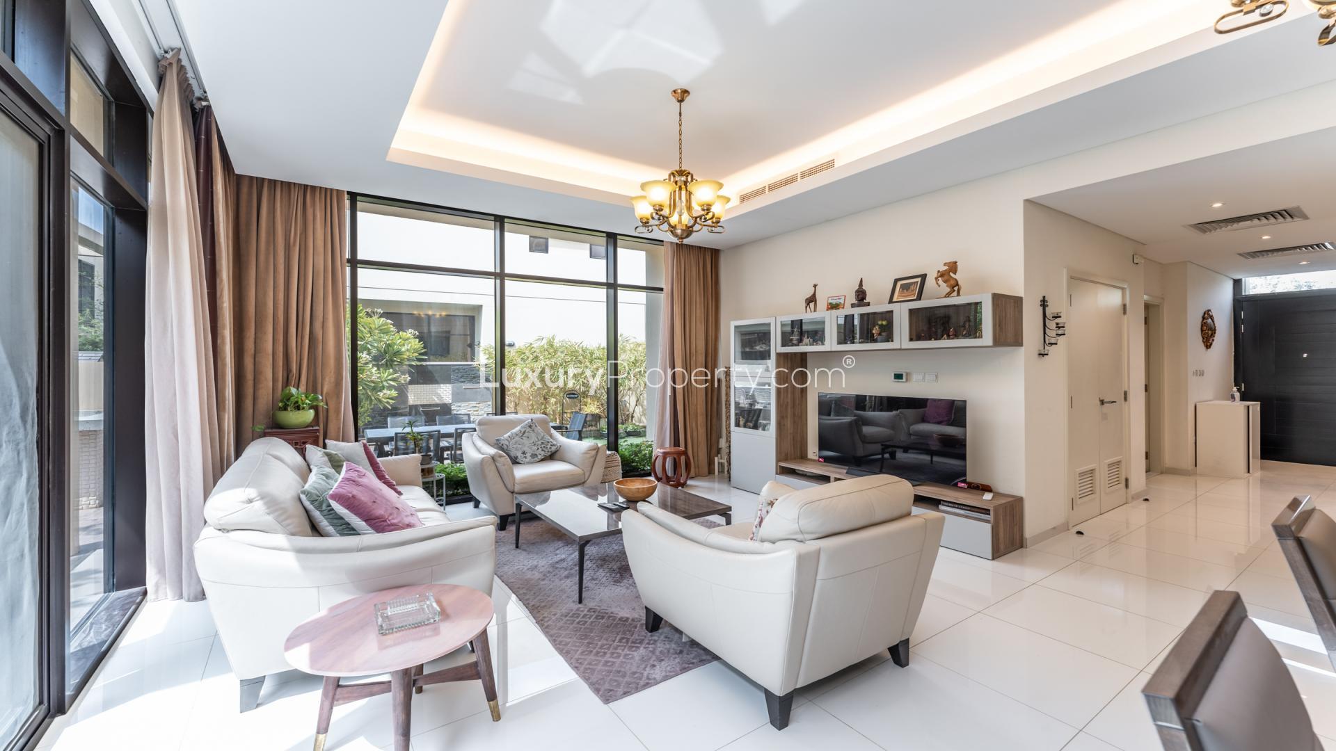 "Charming outdoor seating area in Rockwood villa, Damac Hills, surrounded by lush greenery.",Luxurious living room in furnished 3-bed villa, Damac Hills, Rockwood community, for rent