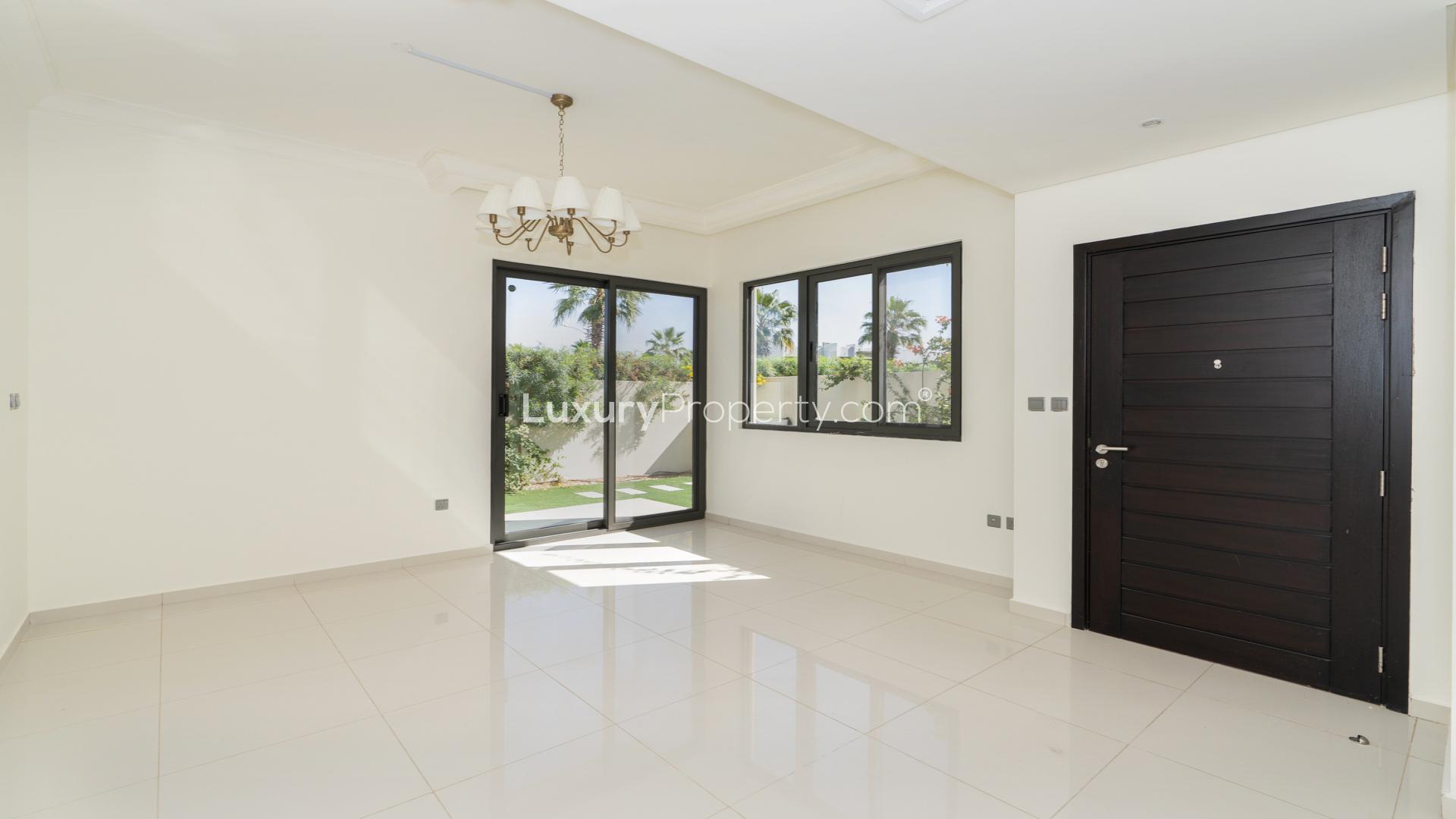 "Bright living area in unfurnished 3BR villa, Odora, Damac Hills 2, with garden view.","Modern villa exterior with garden in Damac Hills 2, Odora community, for rent.",Modern kitchen in spacious 3BR villa, Damac Hills 2, Odora, available for rent