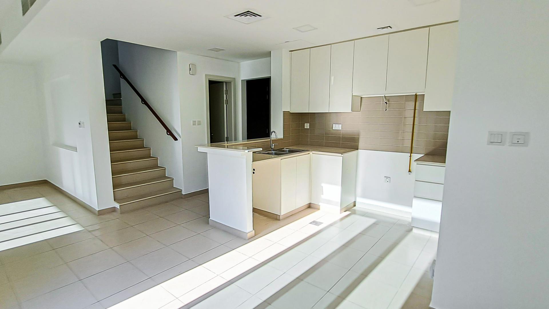 Charming Naseem townhouse interior with modern kitchen, living area, and staircase view