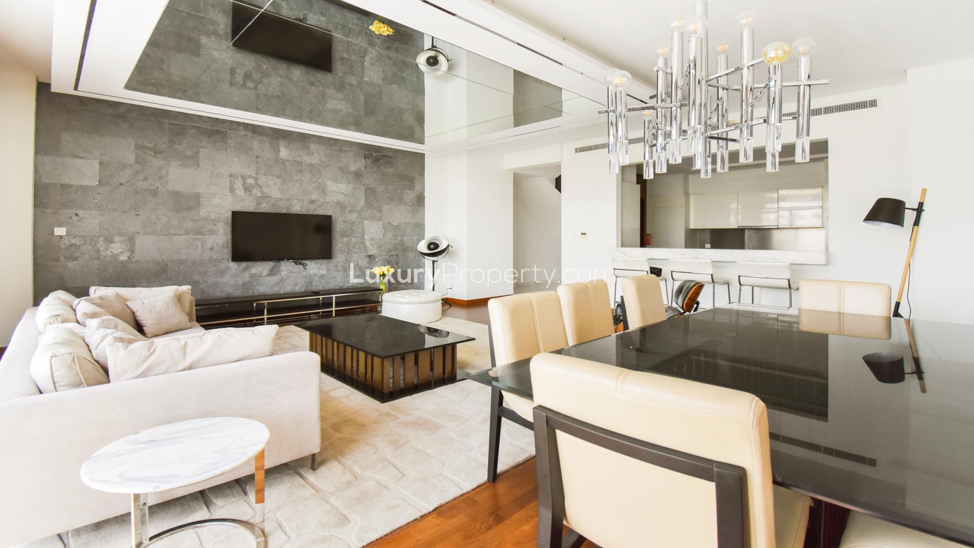 Luxurious living room in fully furnished Damac Hills villa with modern decor and dining area