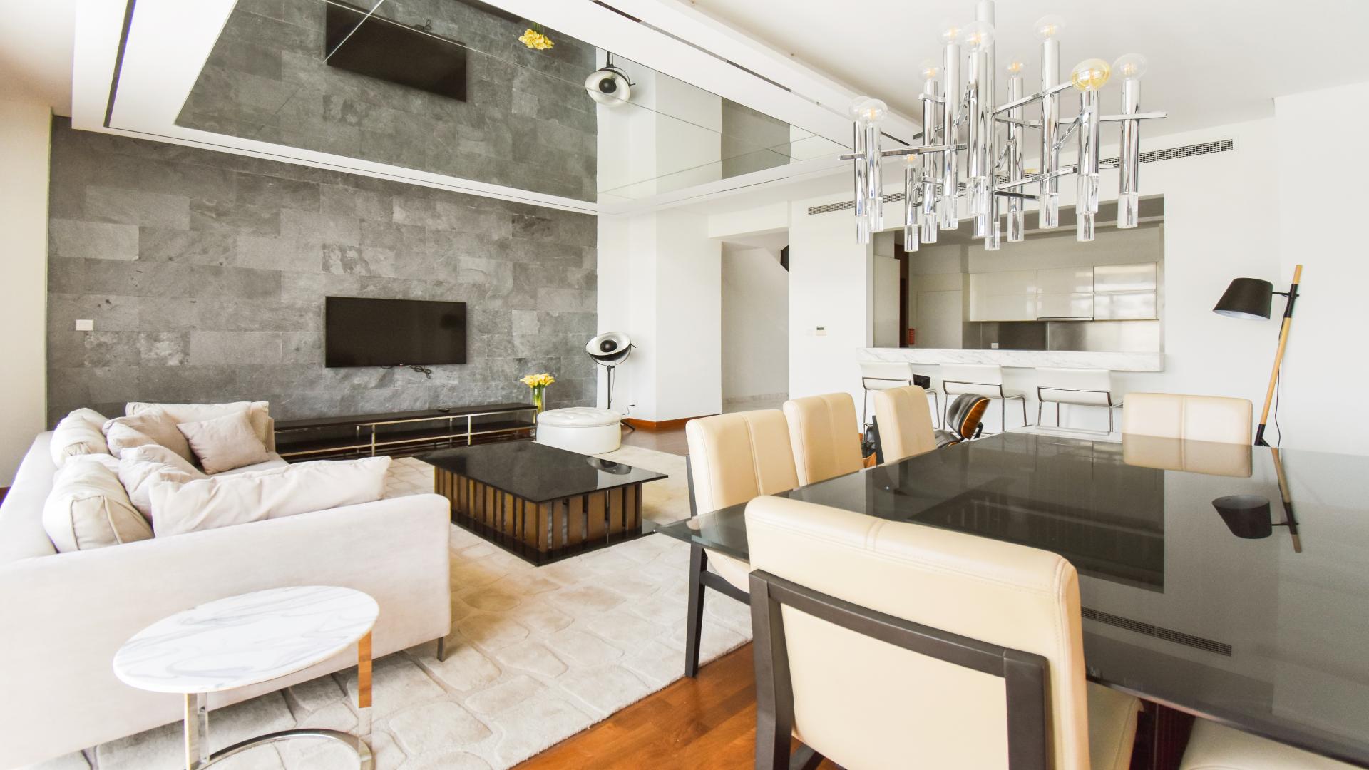 Luxurious living room in fully furnished Damac Hills villa with modern decor and dining area