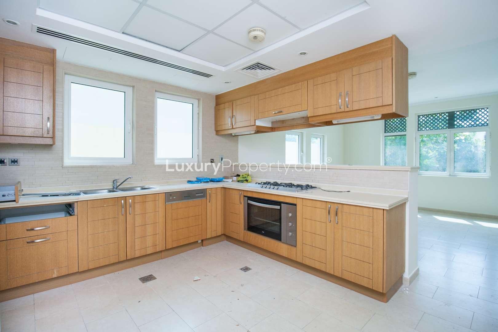 Spacious bedroom with built-in wardrobes and balcony access in Jumeirah Park villa for rent